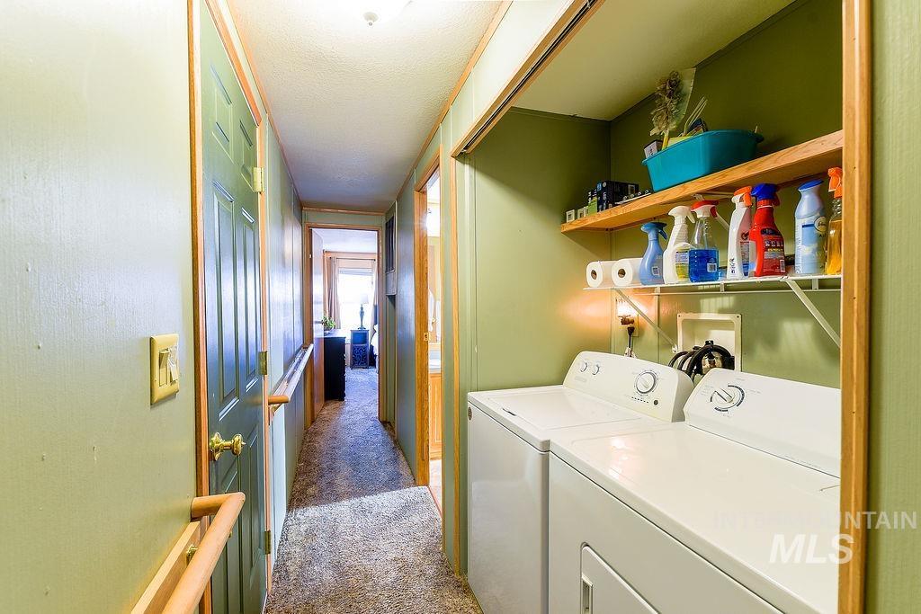 Laundry area with carpet, separate washer and dryer, and a textured ceiling