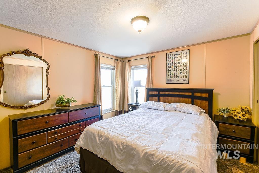 Carpeted bedroom with a textured ceiling and crown molding