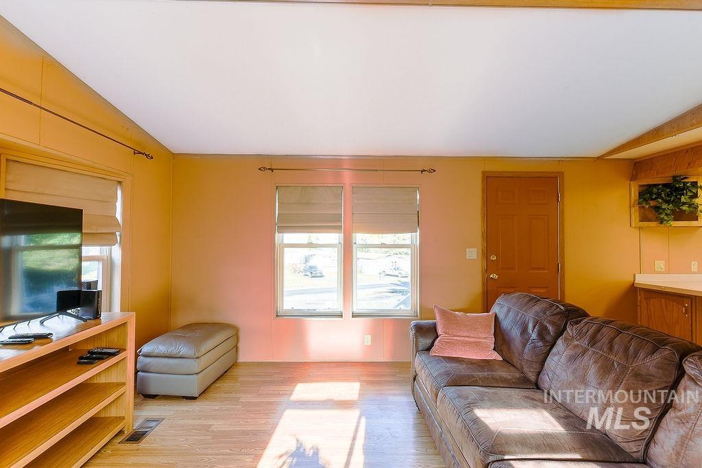 Living room featuring light wood-type flooring and vaulted ceiling