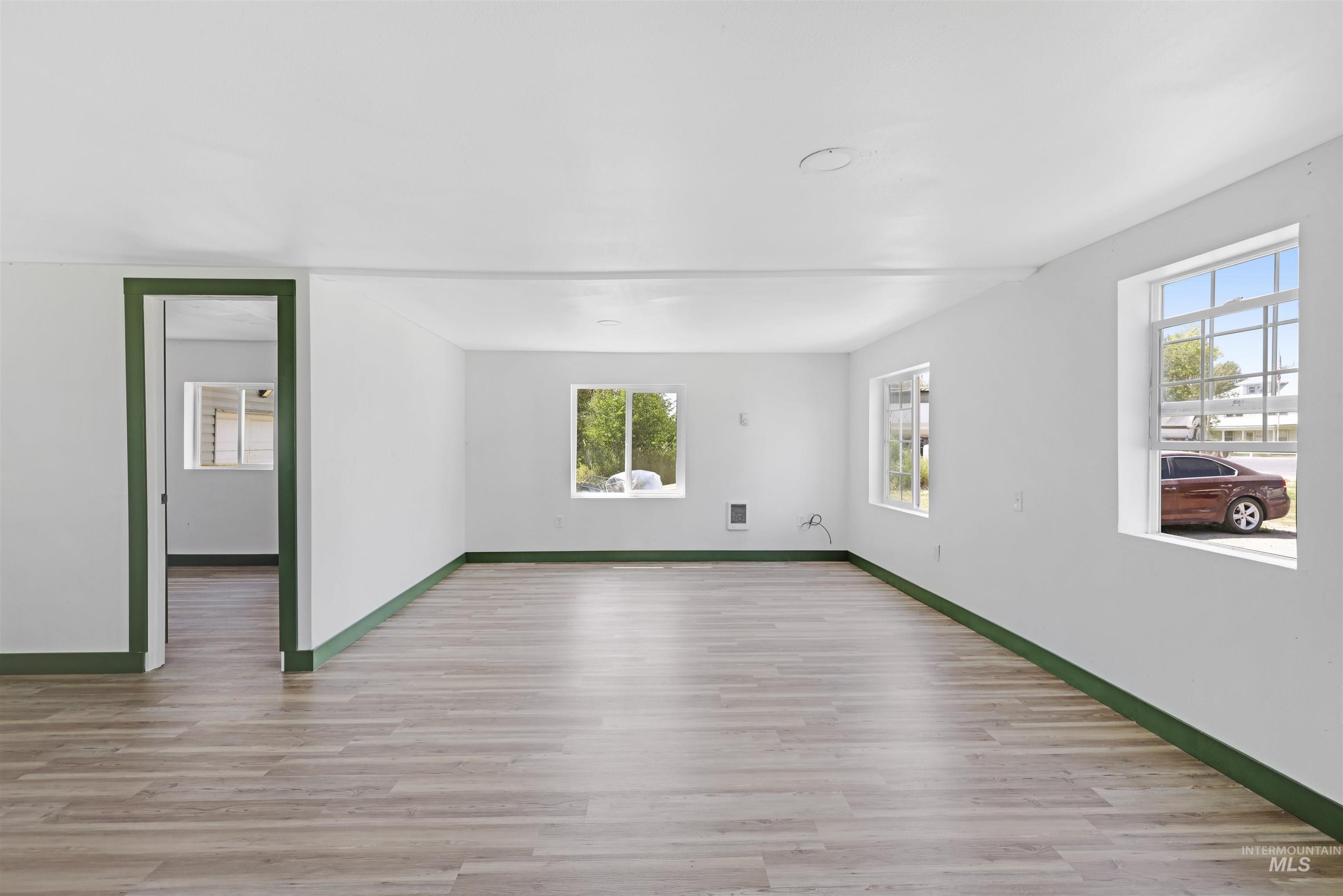 Empty room featuring light wood-type flooring and healthy amount of natural light