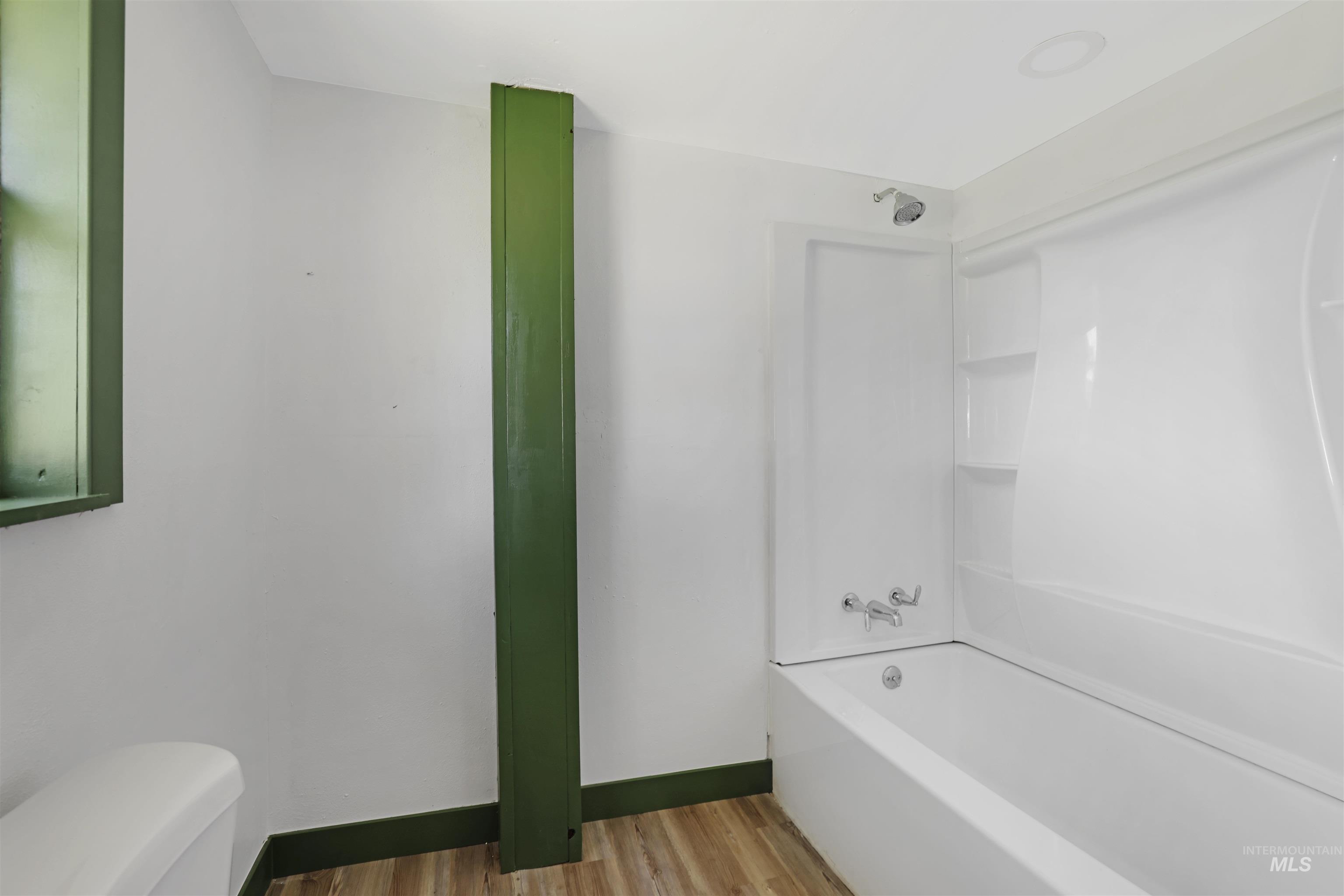 Full bath with shower / bathtub combination and light wood-type flooring