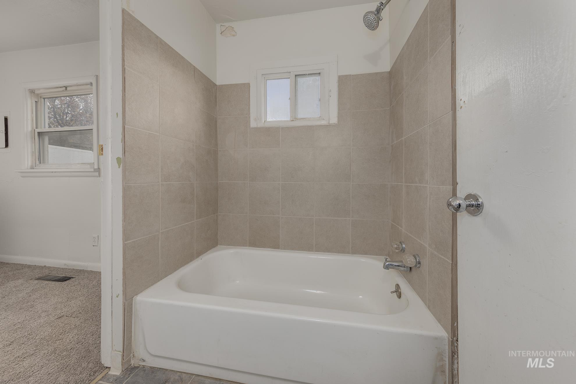 Bathroom featuring carpet and bathtub / shower combination