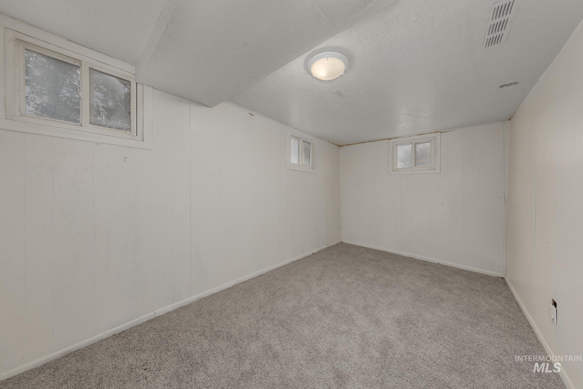 Below grade area with carpet and a textured ceiling