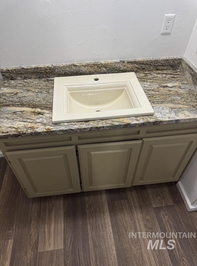 Bathroom featuring vanity and dark wood-style flooring