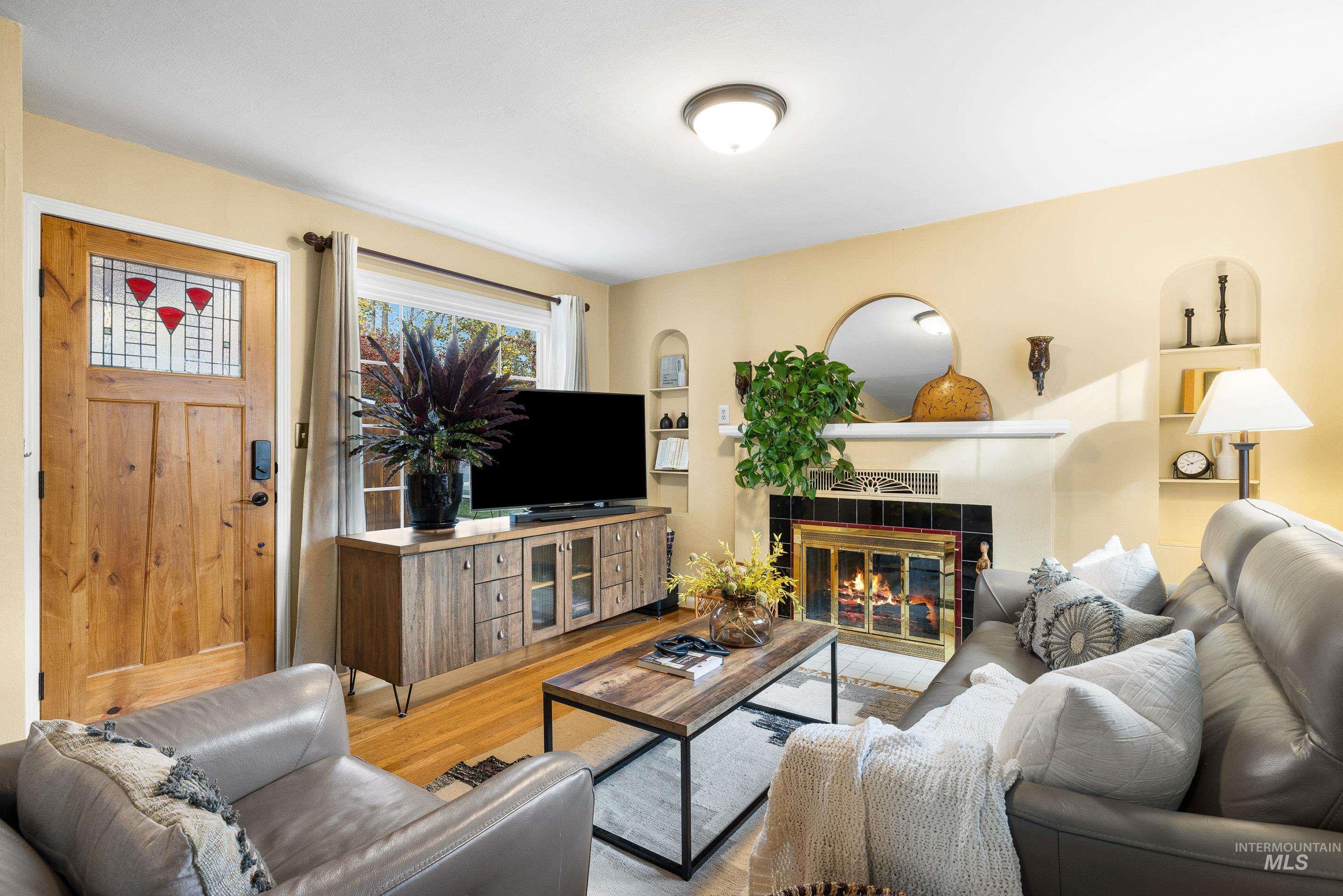 Living room featuring wood finished floors and a tiled fireplace