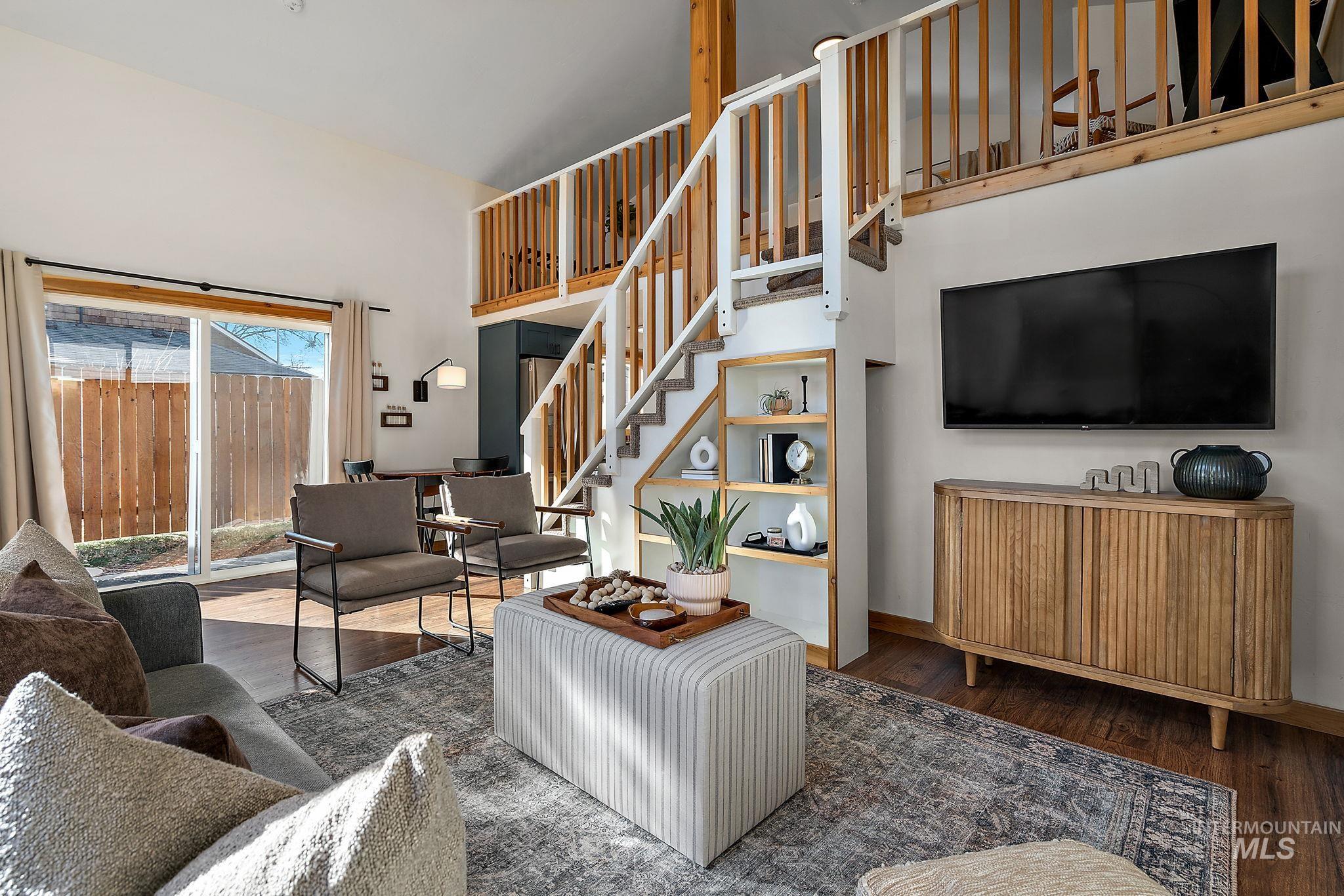 Living area with wood finished floors and stairway