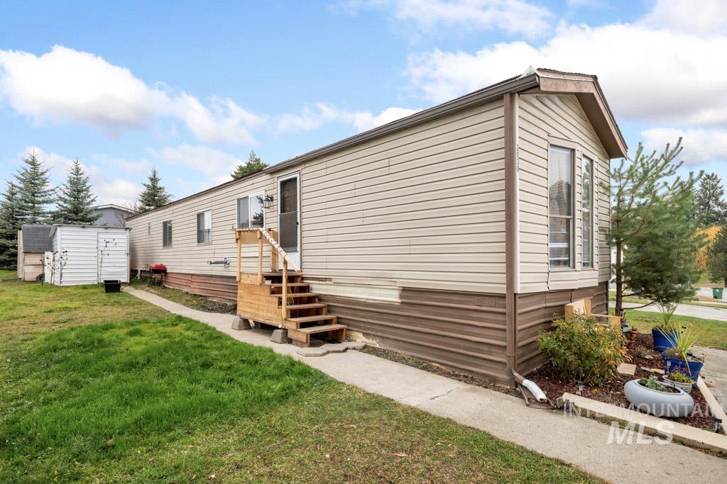 Manufactured / mobile home with a front yard and entry steps