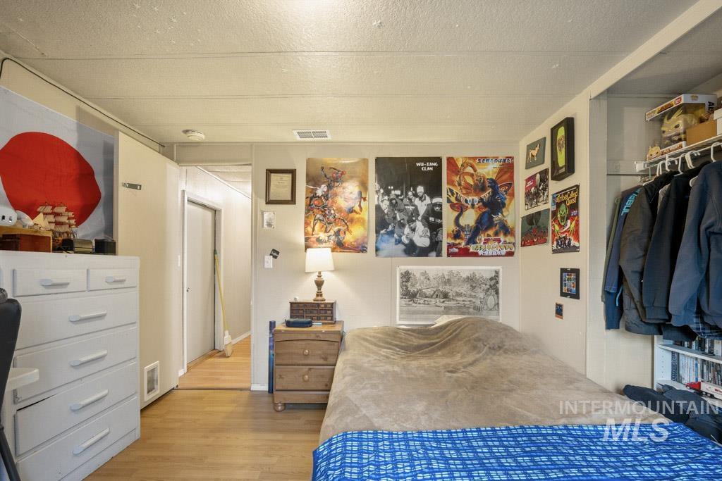 Bedroom featuring wood finished floors and a textured ceiling