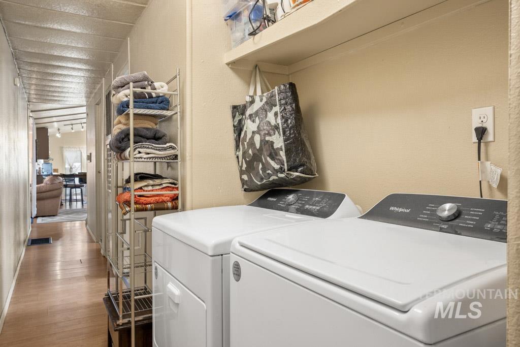 Laundry room featuring dark wood-type flooring and washing machine and clothes dryer
