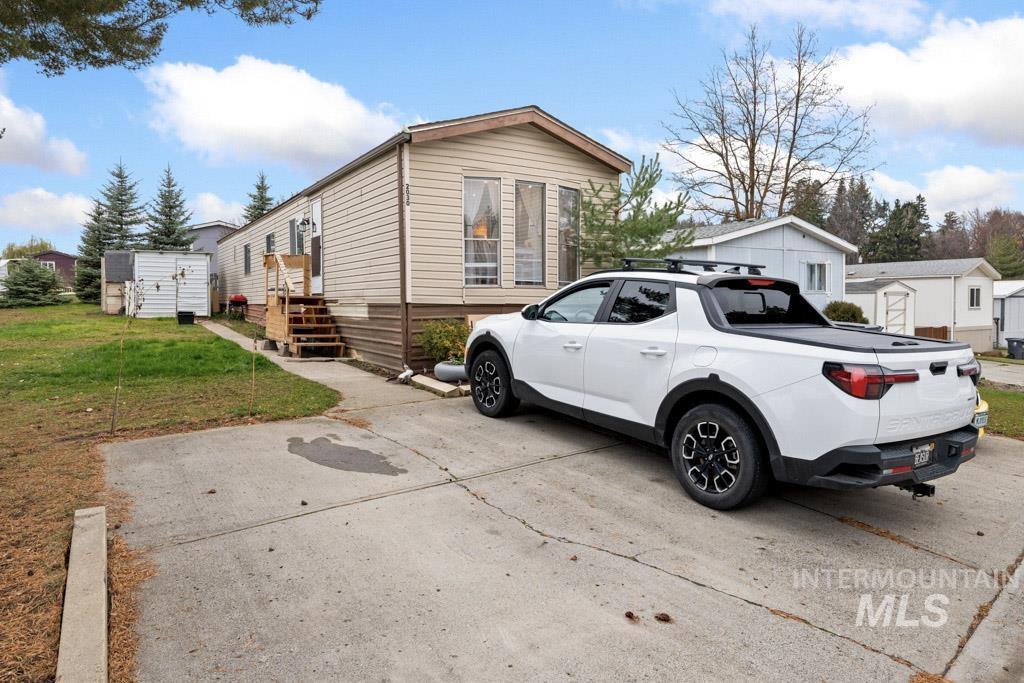 View of side of property with a storage shed and a yard