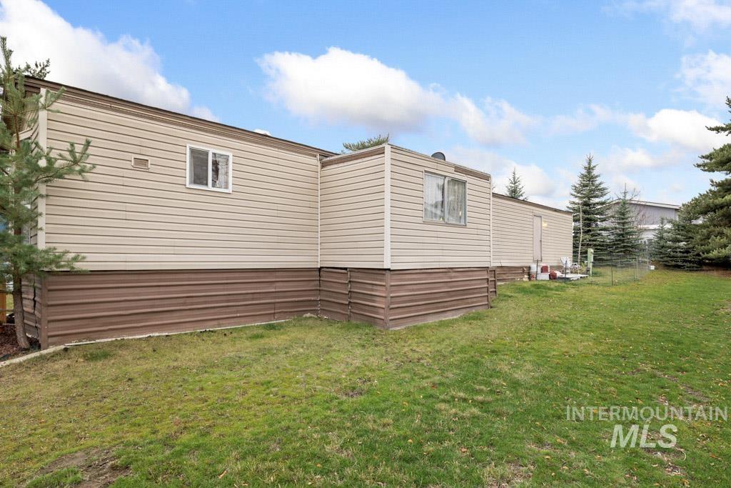 View of side of home featuring a yard