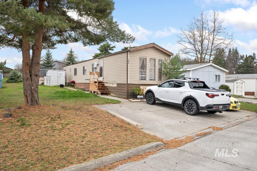 View of front of home with an outdoor structure and a front lawn