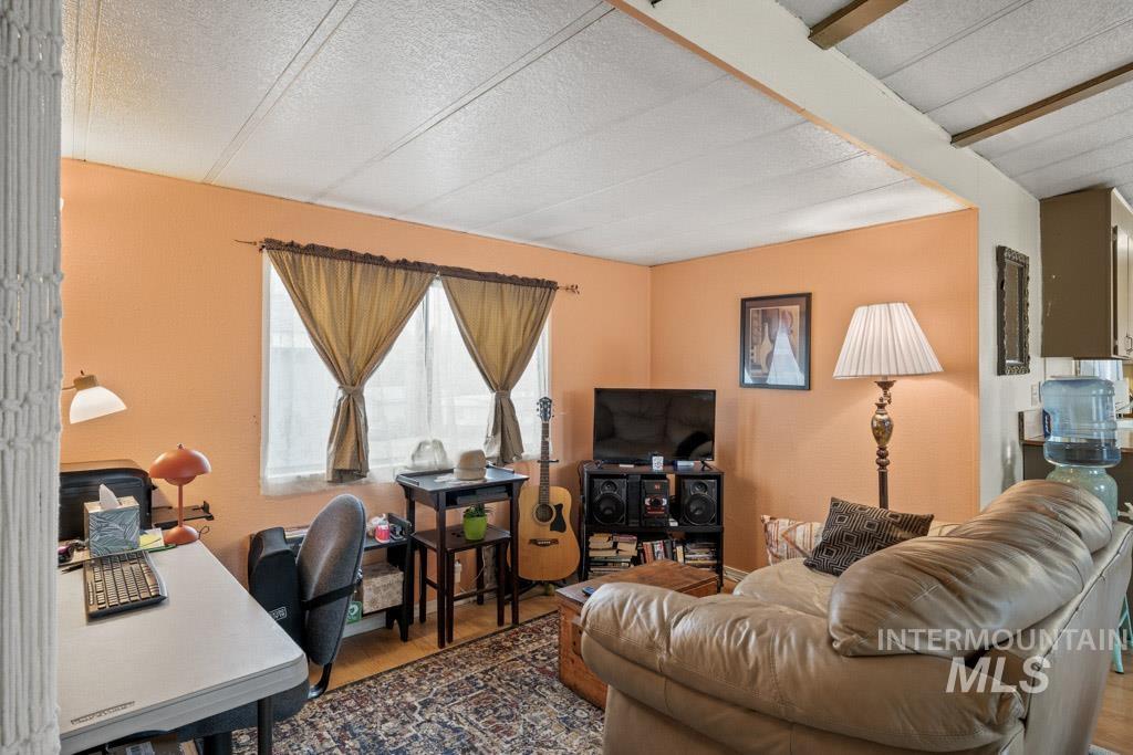 Living room featuring an office area, wood finished floors, and a textured ceiling