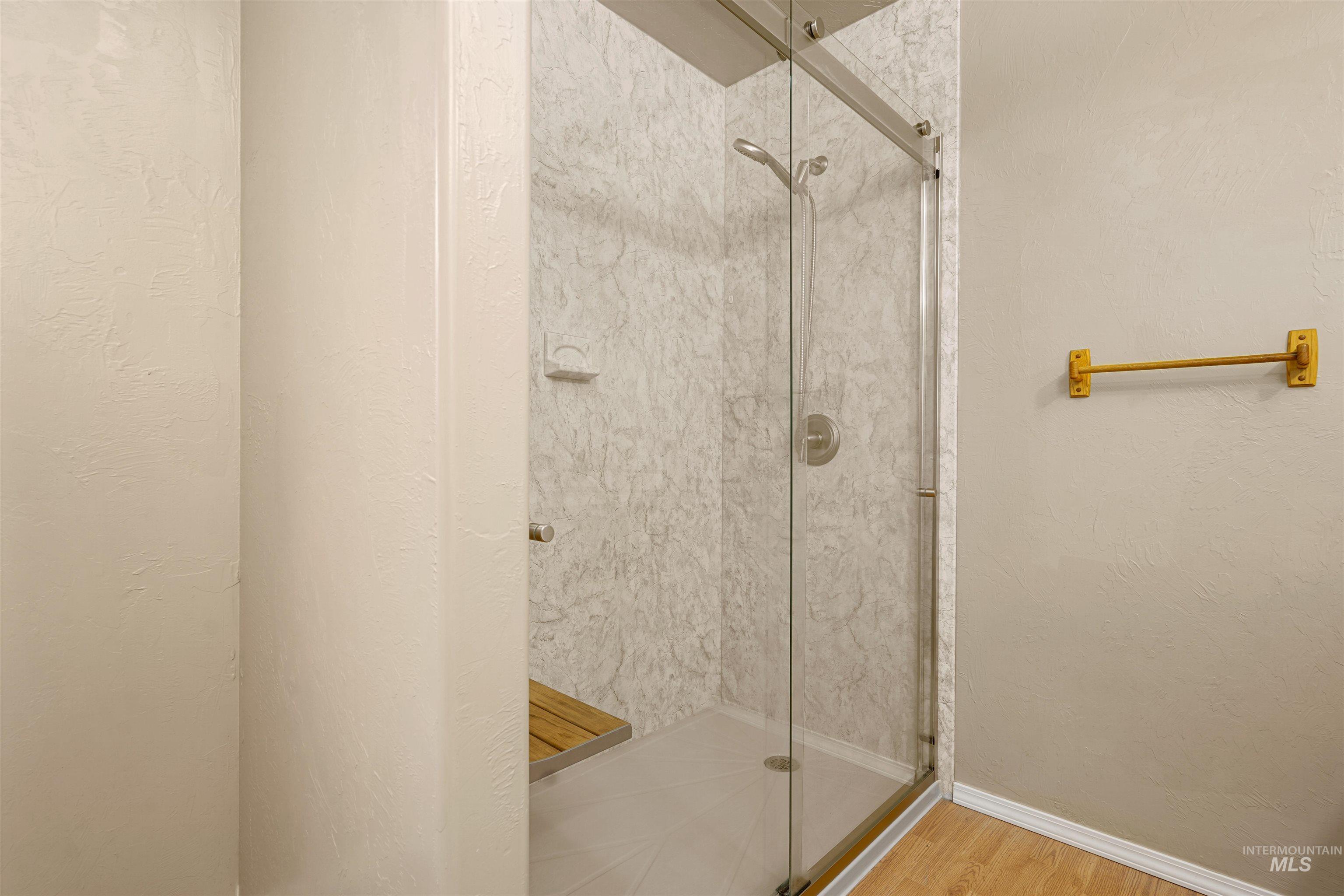 Full bath with a shower stall and a textured wall