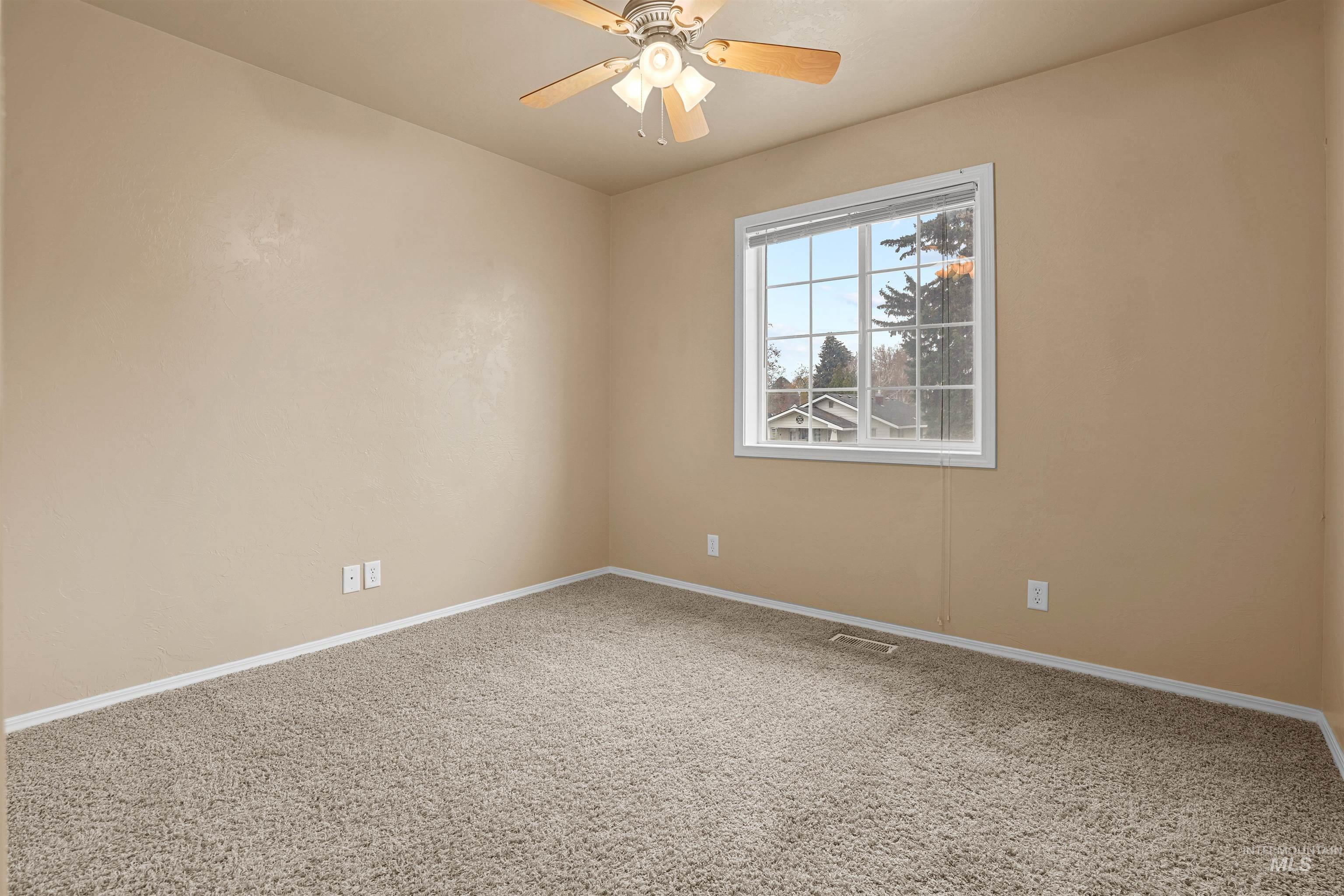 Empty room with carpet flooring and ceiling fan