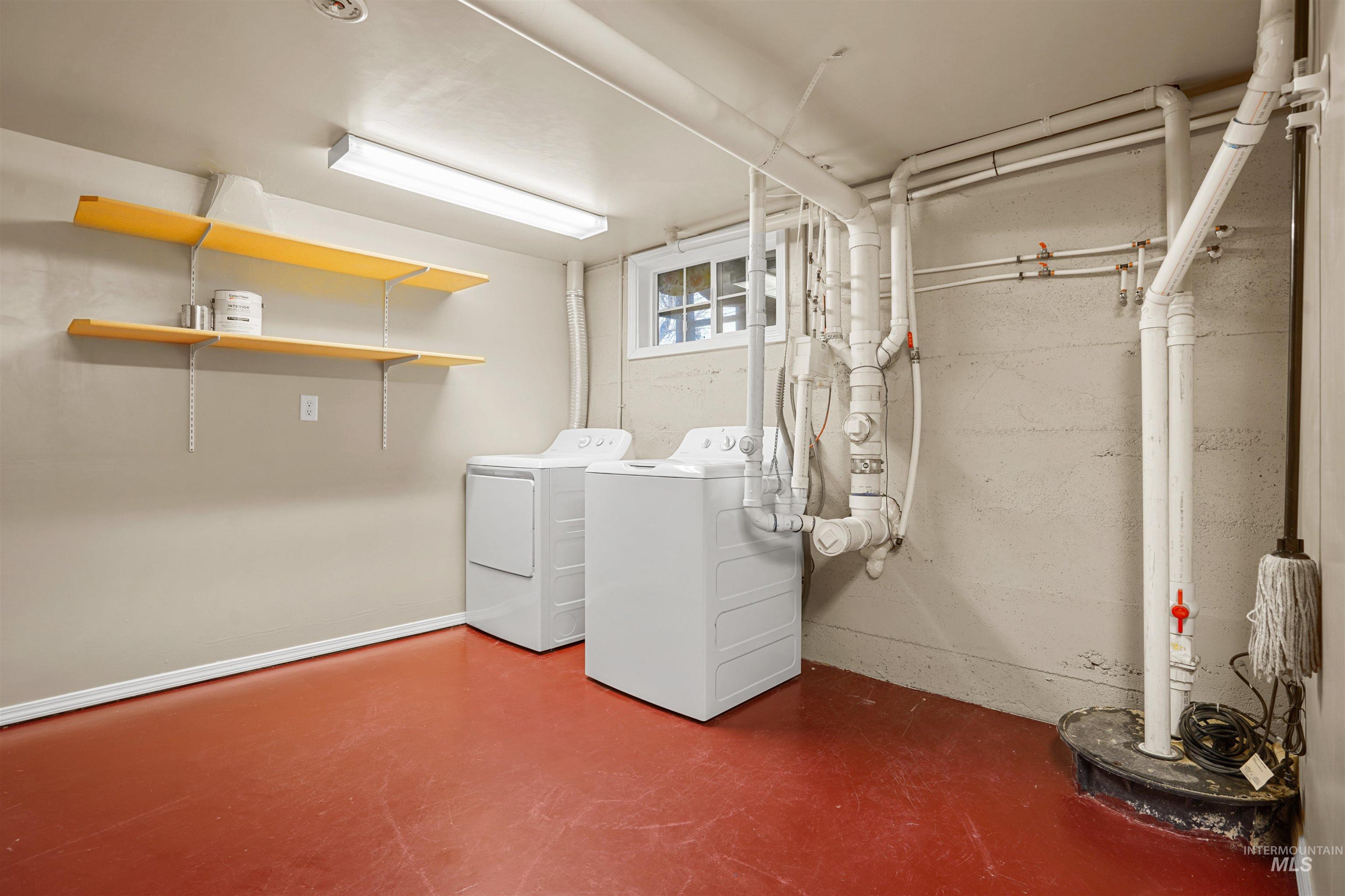 Washroom featuring concrete floors and washer and clothes dryer