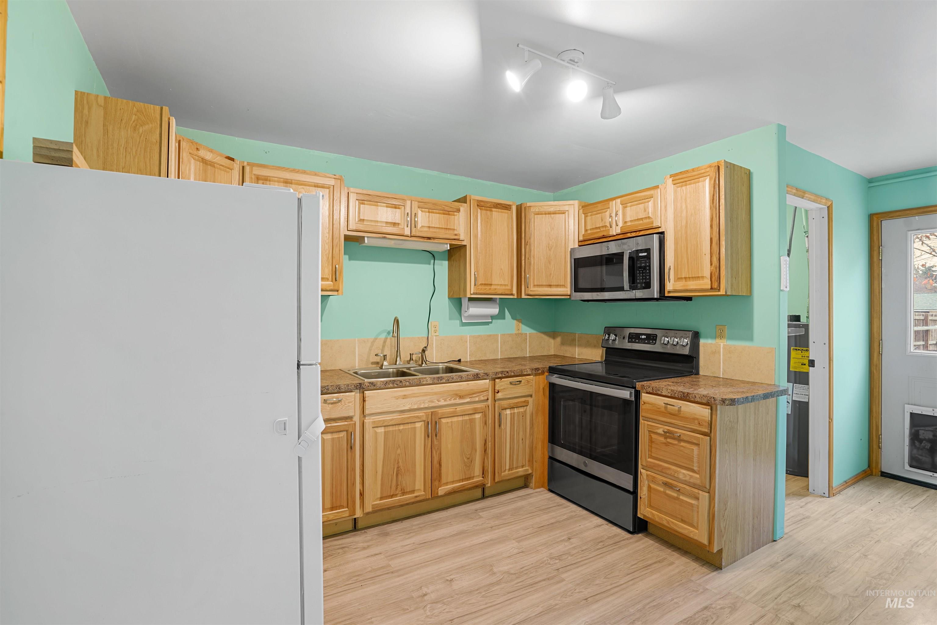 Kitchen featuring stainless steel appliances, light wood-style floors, and light brown cabinetry