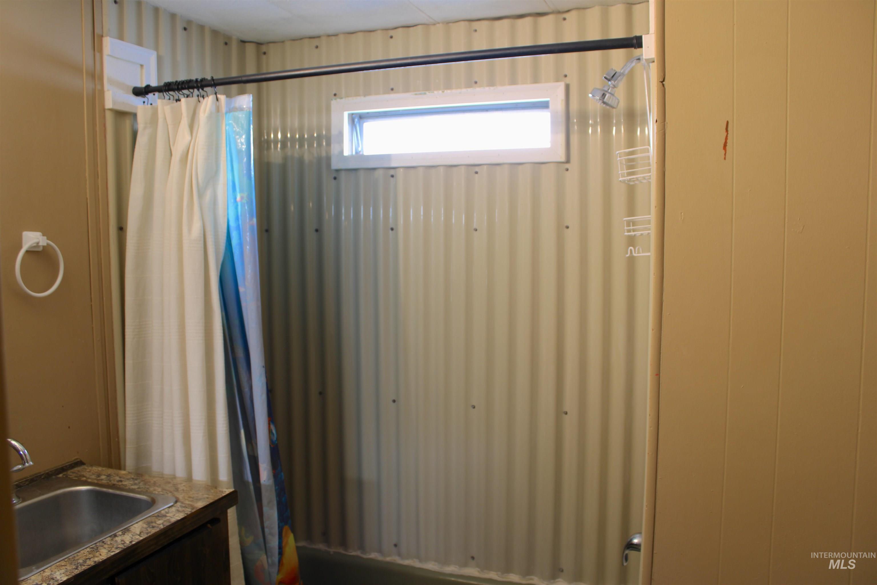 Bathroom with vanity and shower / tub combo with curtain