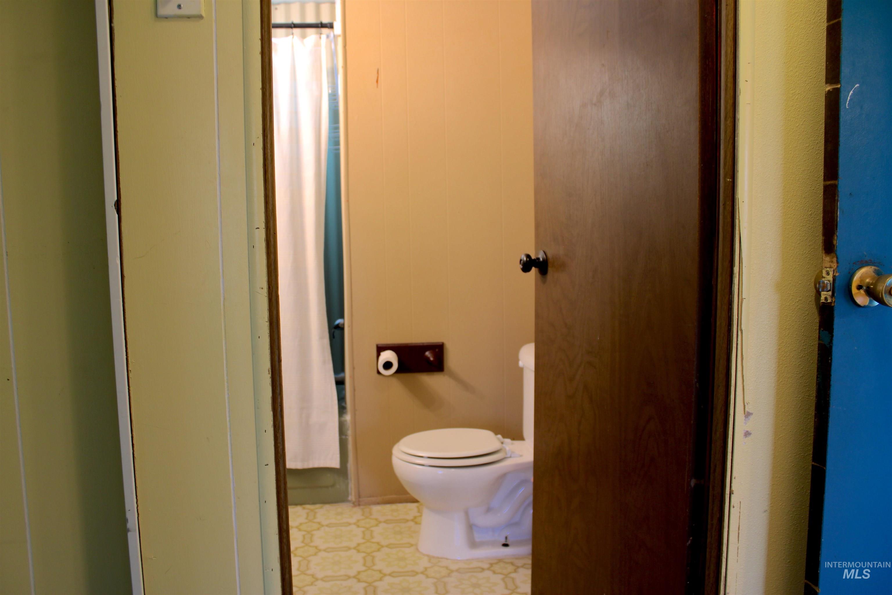 Bathroom featuring light flooring and toilet