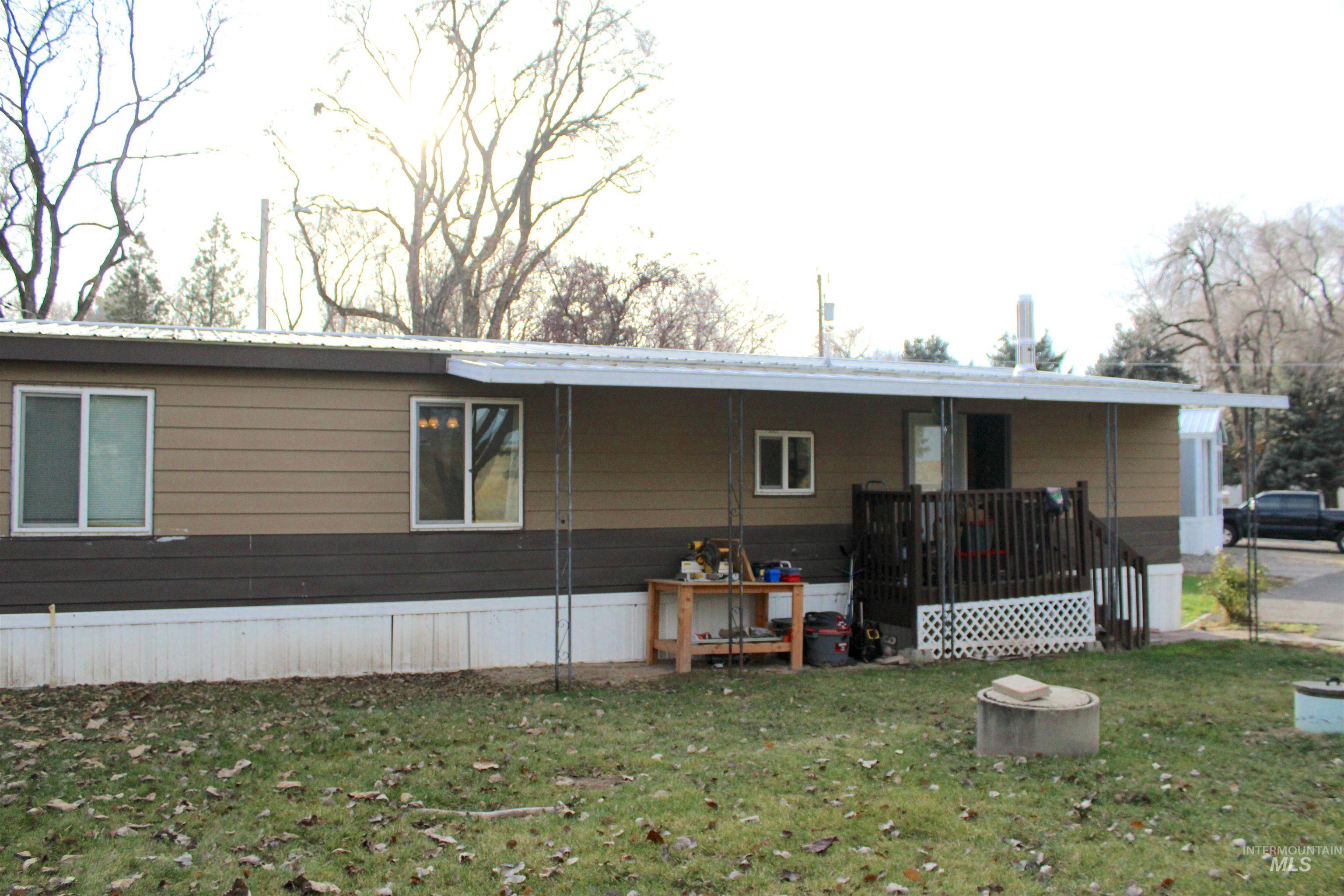 Side view of property featuring a wooden deck and a lawn