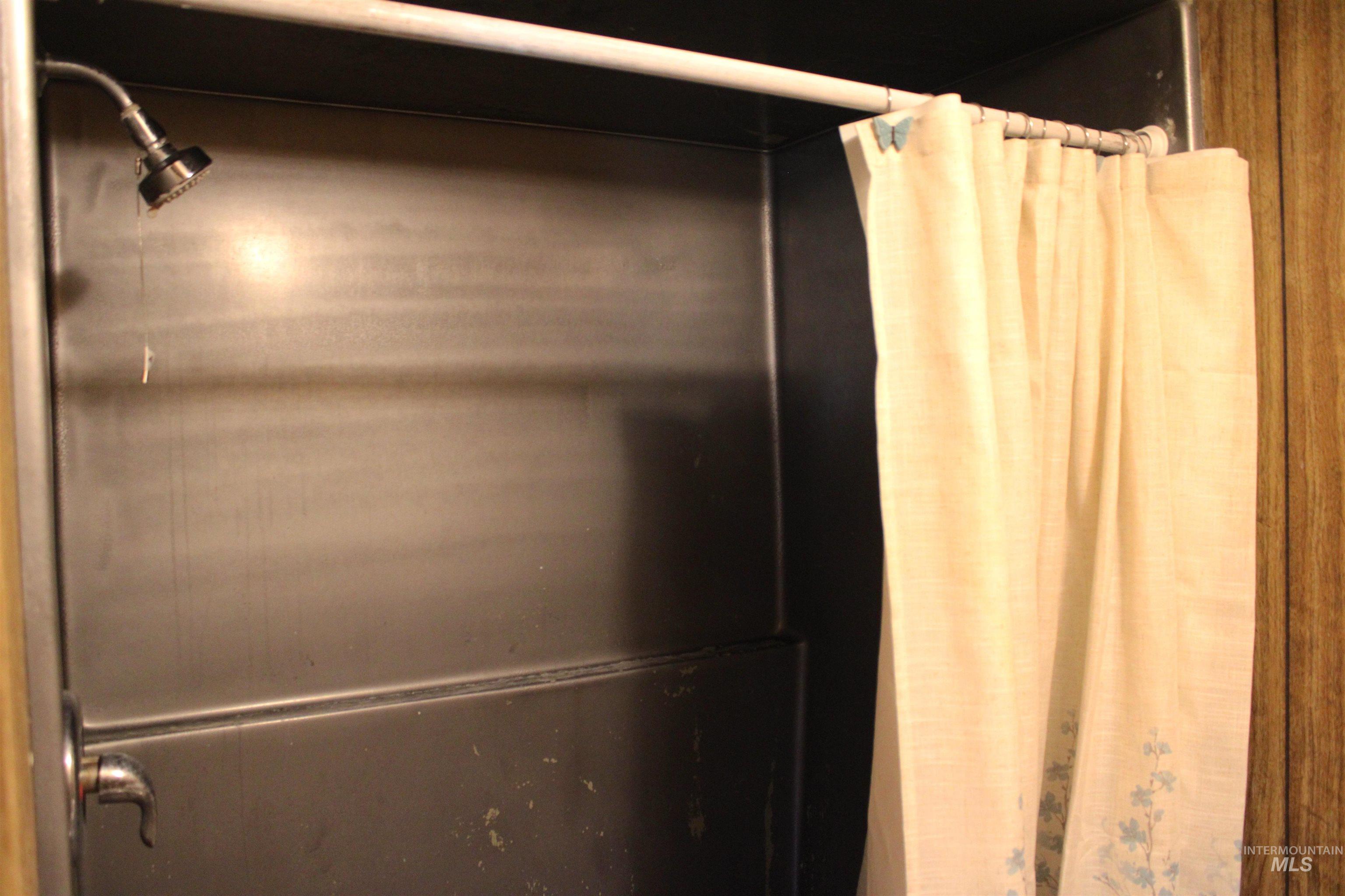Bathroom view of a shower with shower curtain and elevator