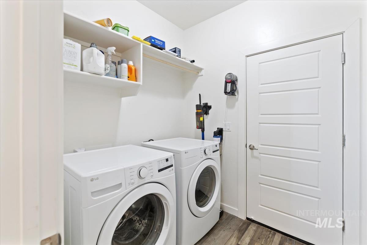 Laundry room featuring dark wood-style flooring and washing machine and clothes dryer