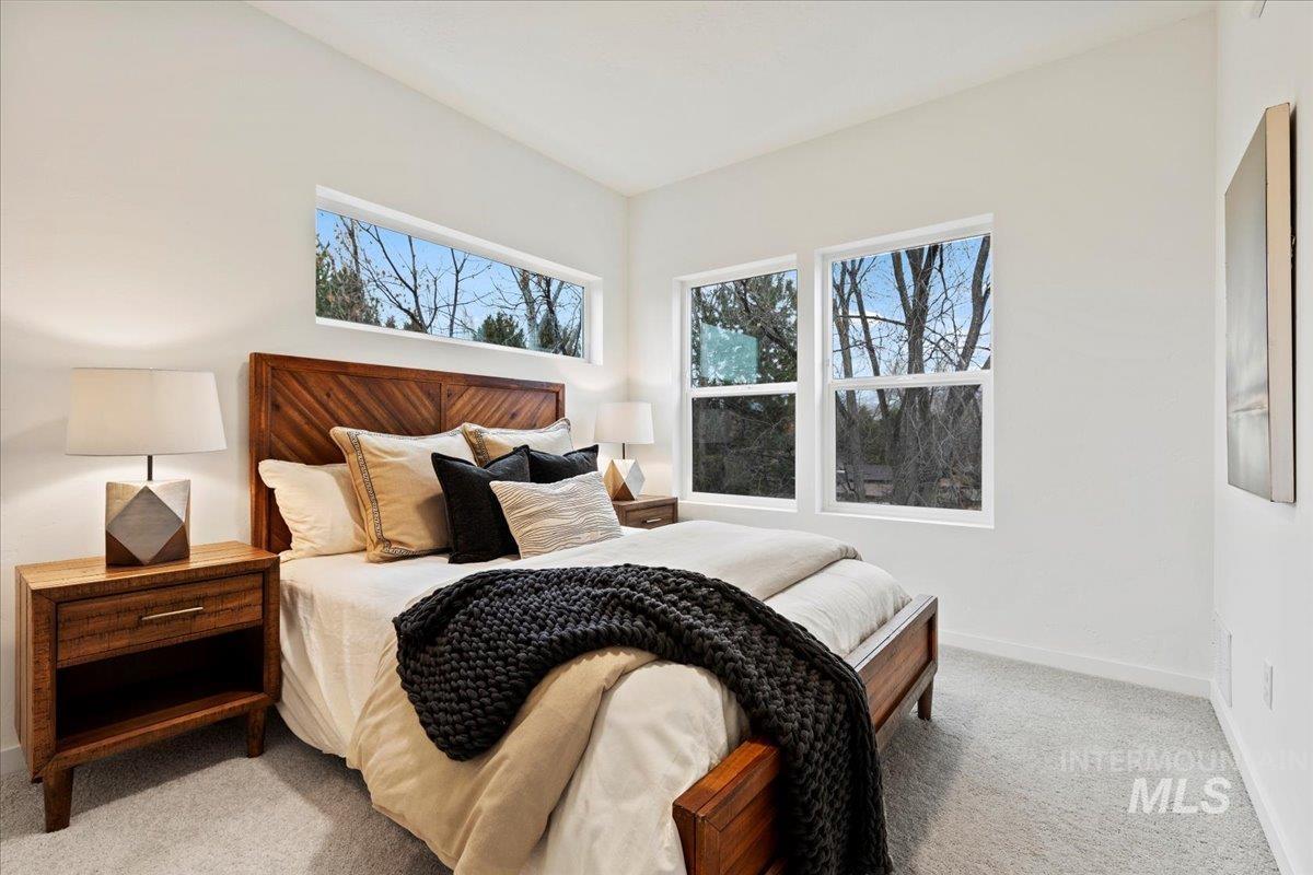 Bedroom with light colored carpet and baseboards