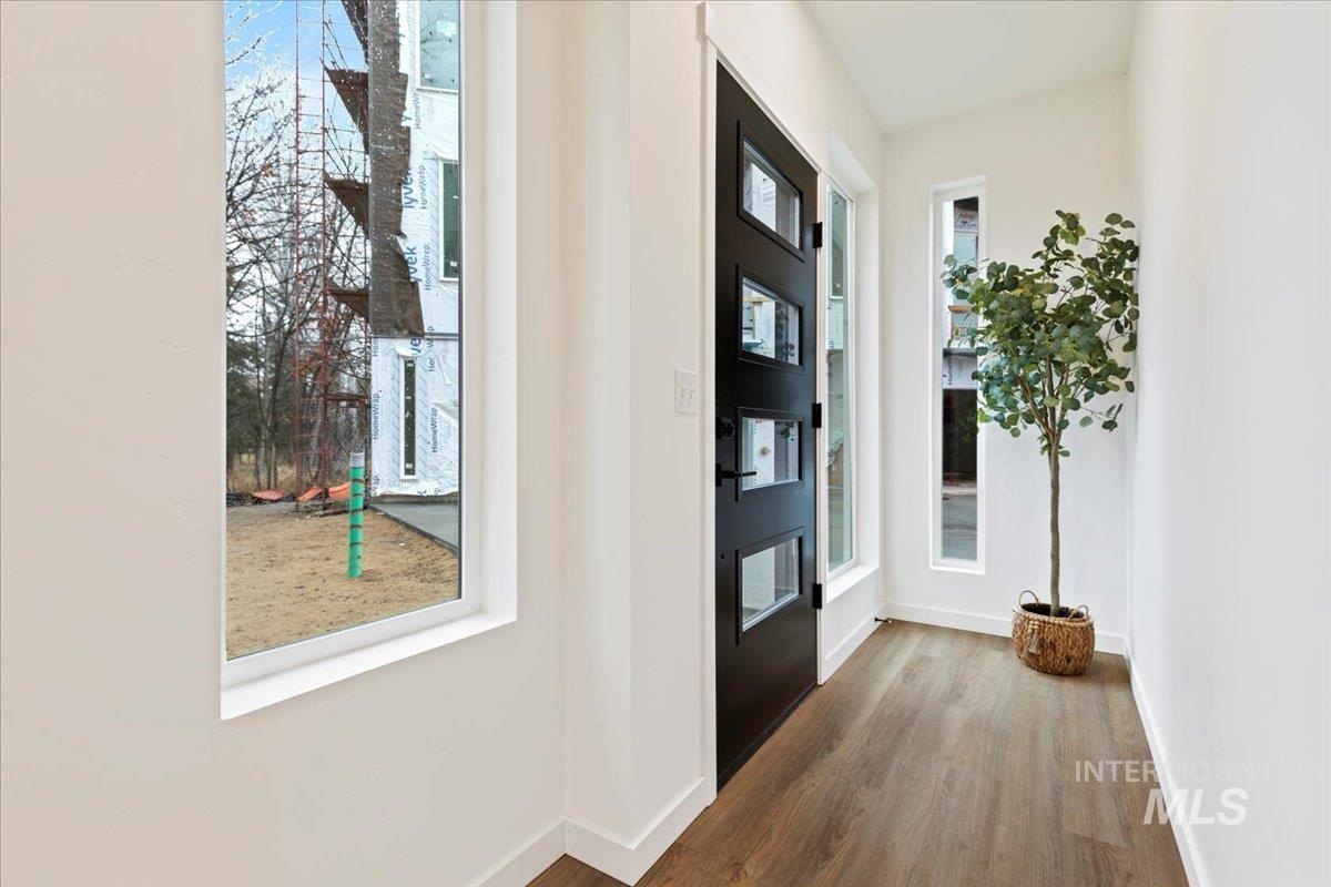 Entryway featuring dark wood-type flooring and baseboards