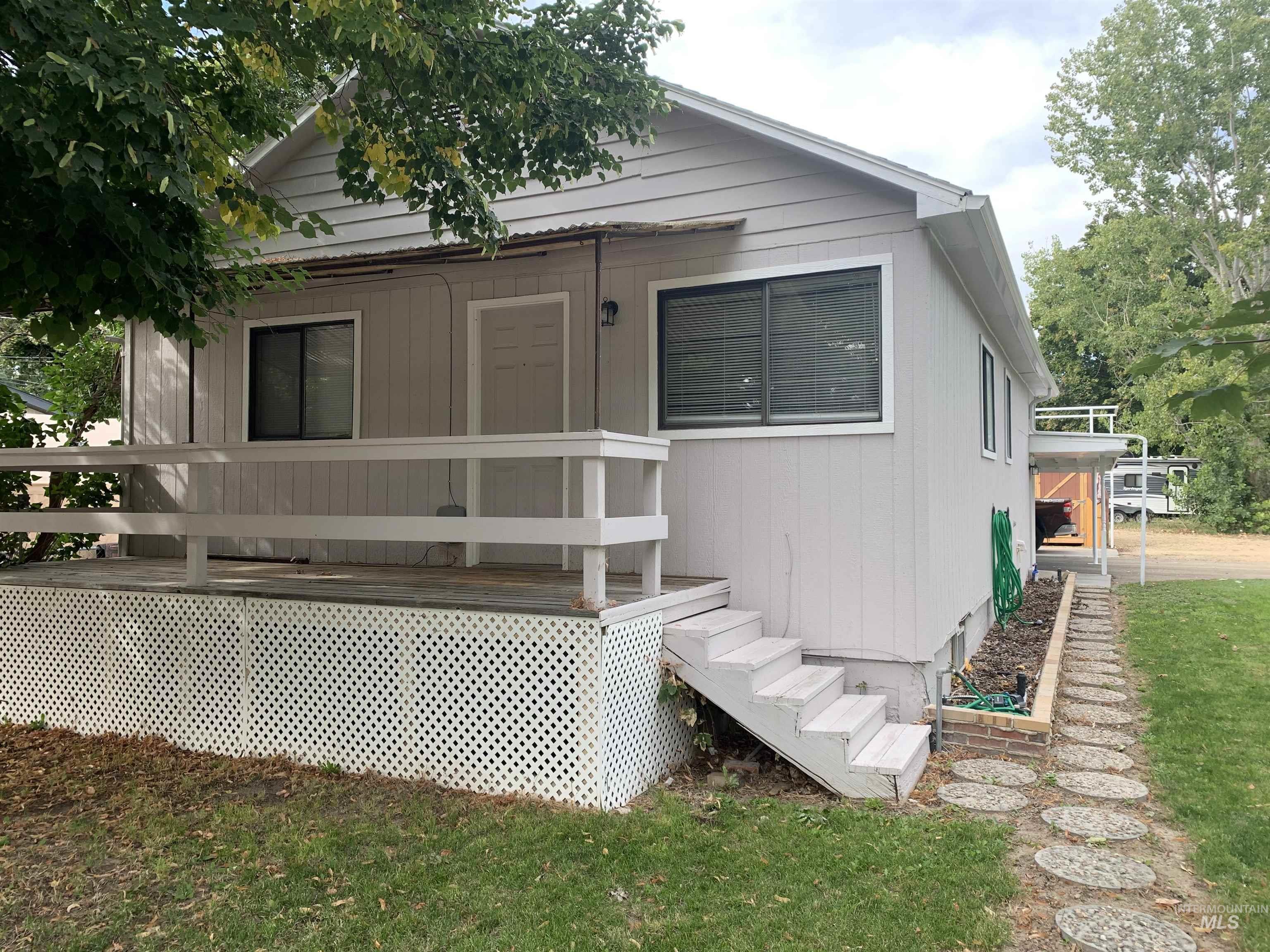 View of front of house featuring a wooden deck and a front lawn