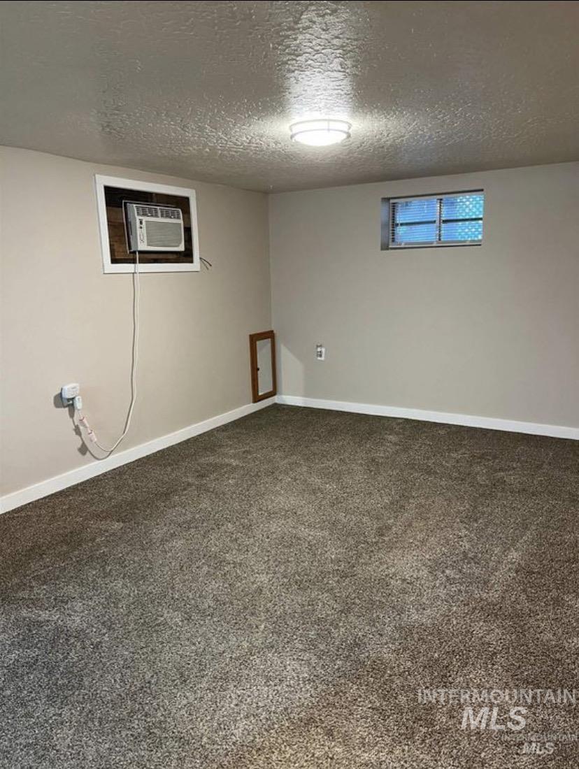 Finished below grade area featuring a textured ceiling, carpet flooring.