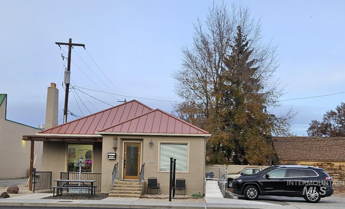 Bungalow with stucco siding, a standing seam roof, and a metal roof