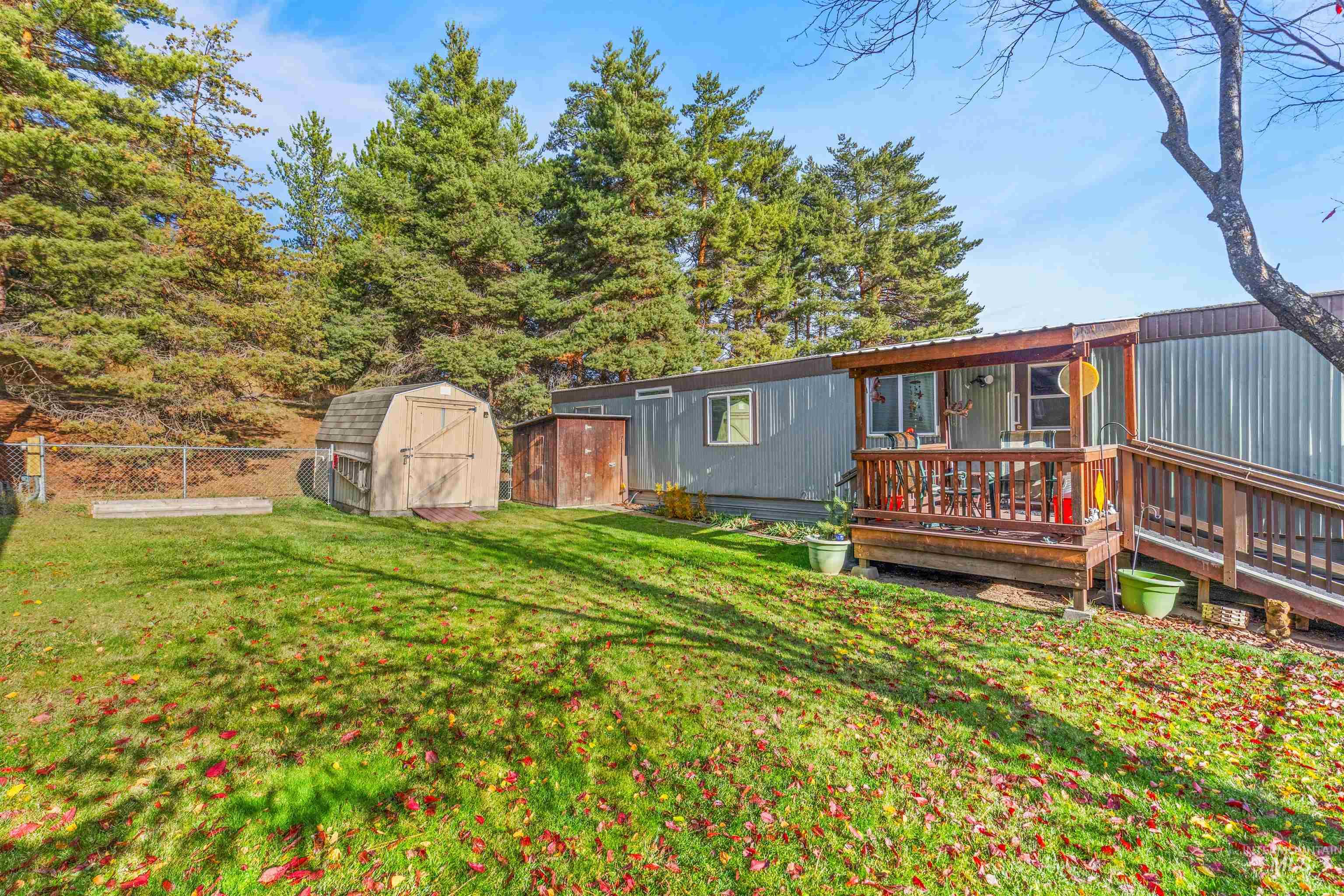 Fenced backyard featuring a shed and a deck
