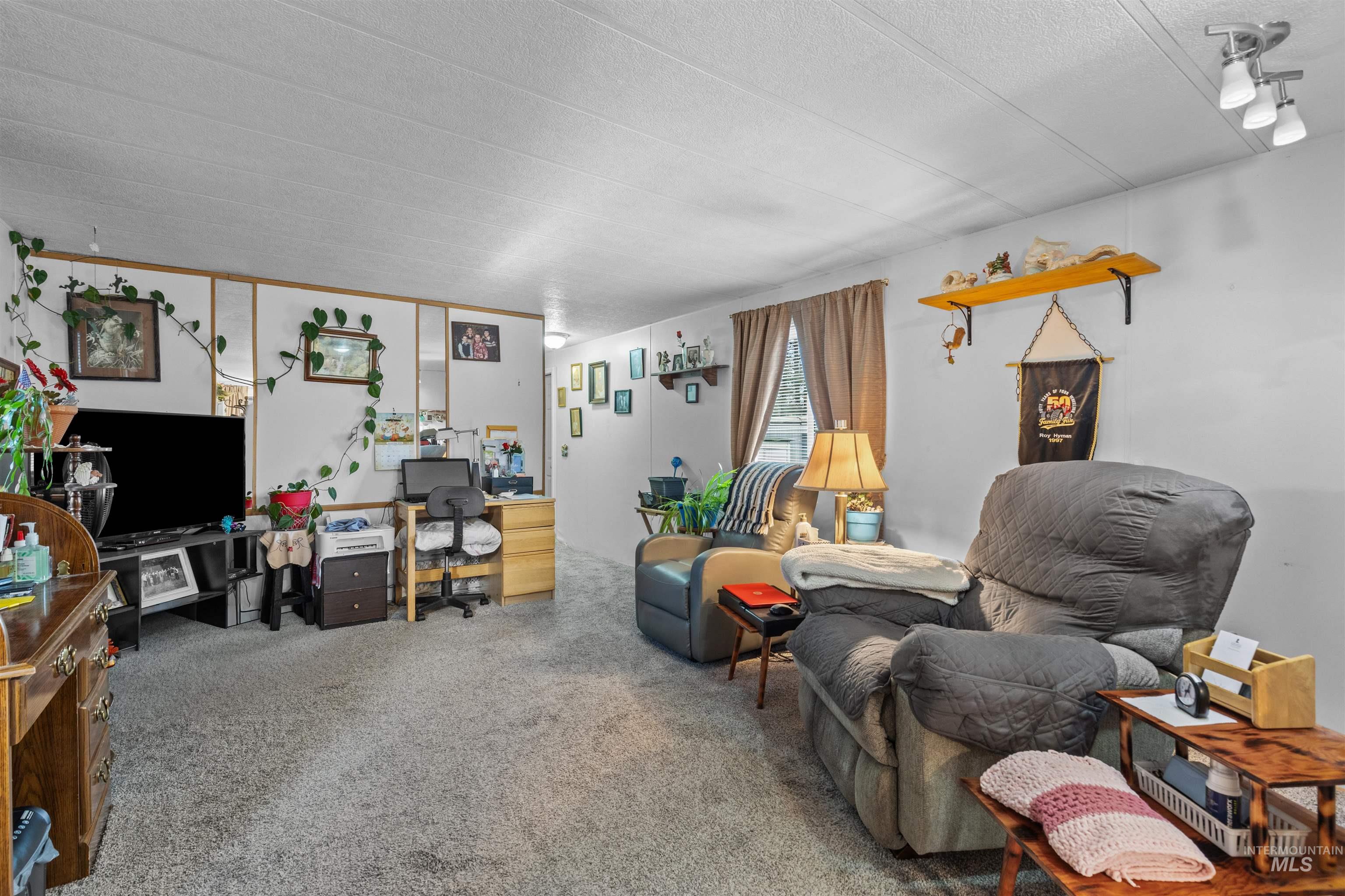 Living area with carpet floors and a textured ceiling