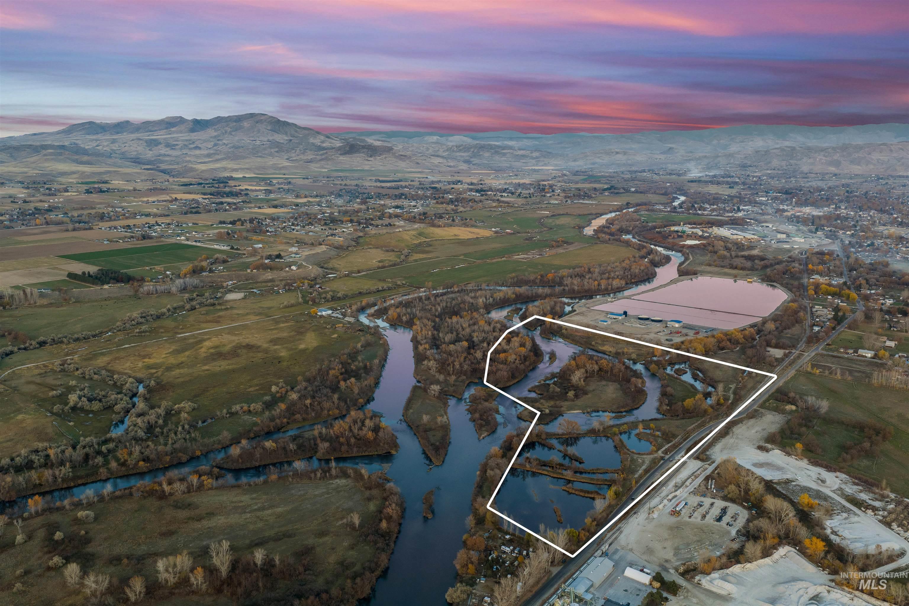 Aerial view at dusk of property boundaries highlighted and a water and mountain view