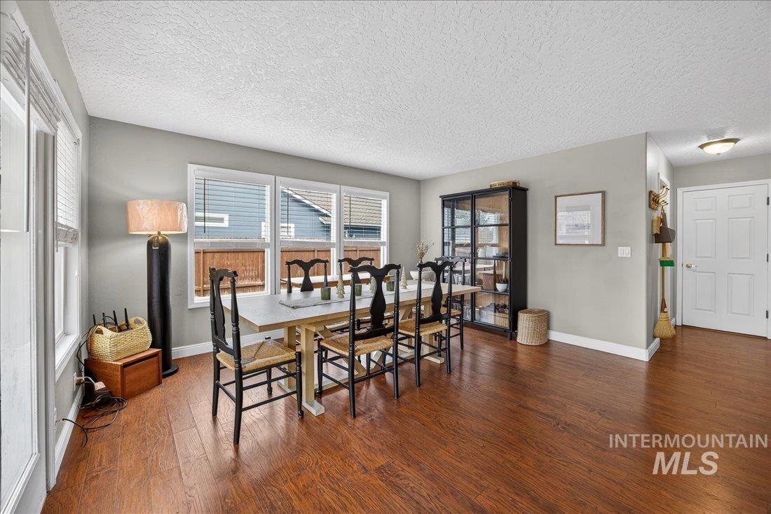 Dining area featuring a textured ceiling and dark wood-type flooring