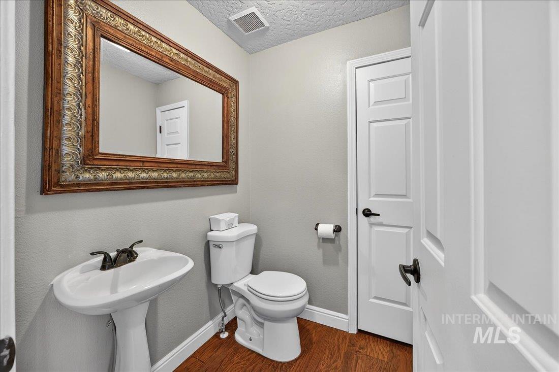Bathroom featuring dark wood-style flooring and a textured ceiling