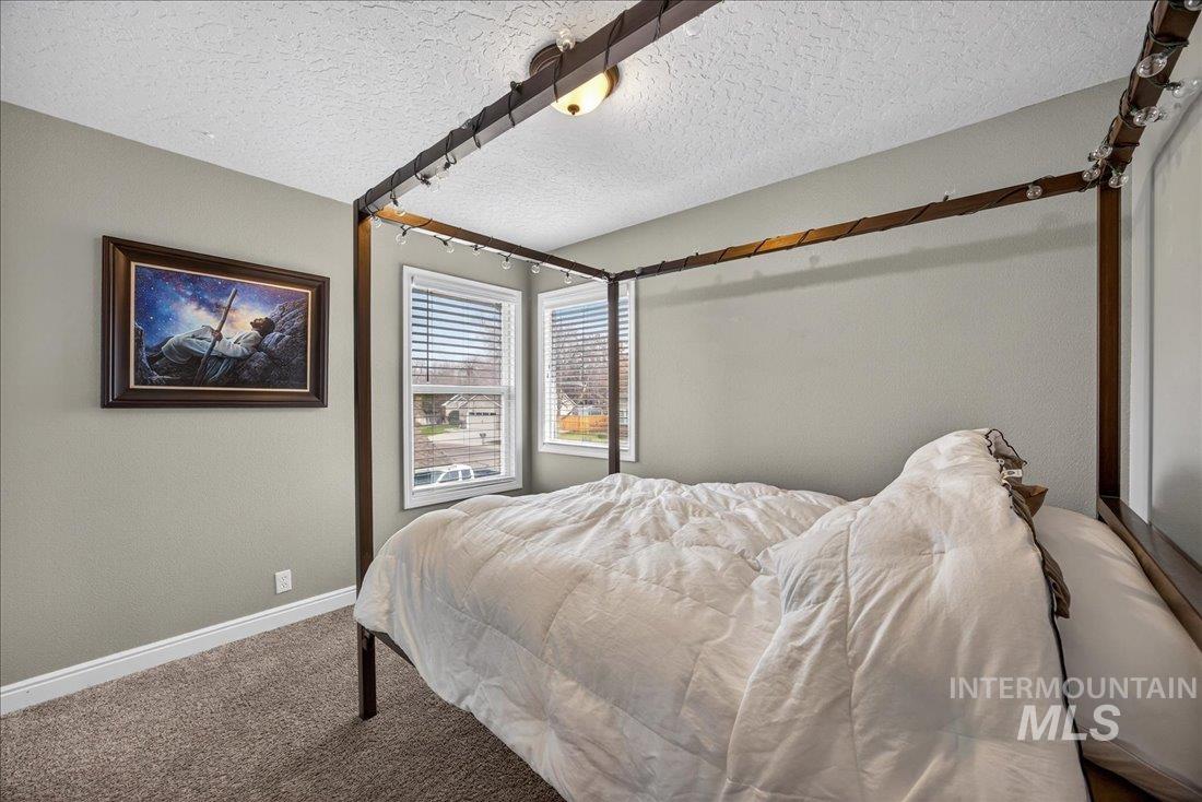 Bedroom featuring carpet flooring and a textured ceiling