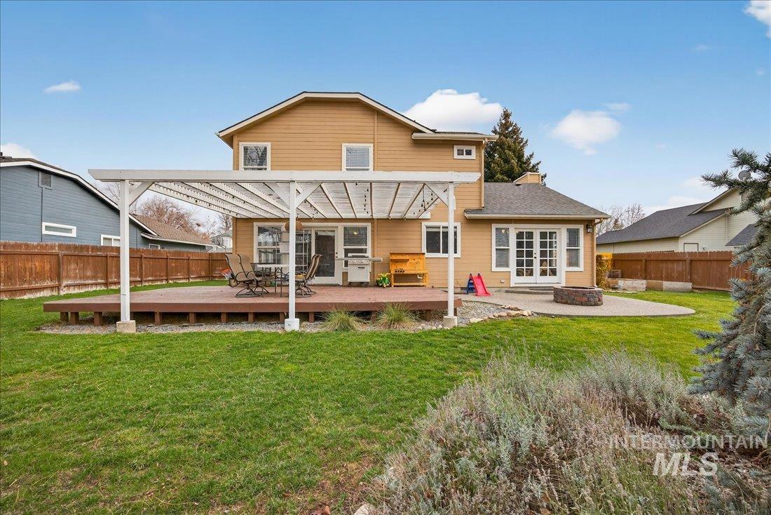 Back of house featuring a fenced backyard, an outdoor fire pit, a deck, and french doors