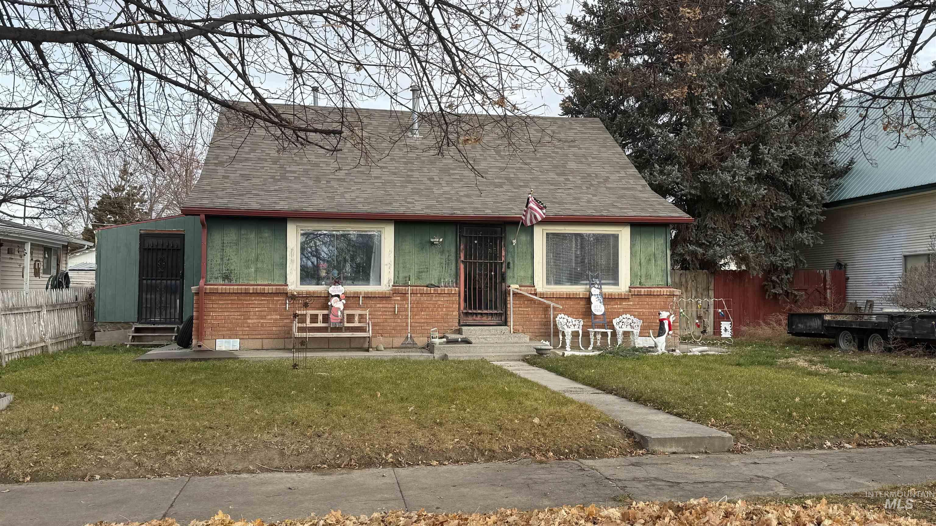 View of front of property featuring entry steps, brick siding, and roof with shingles