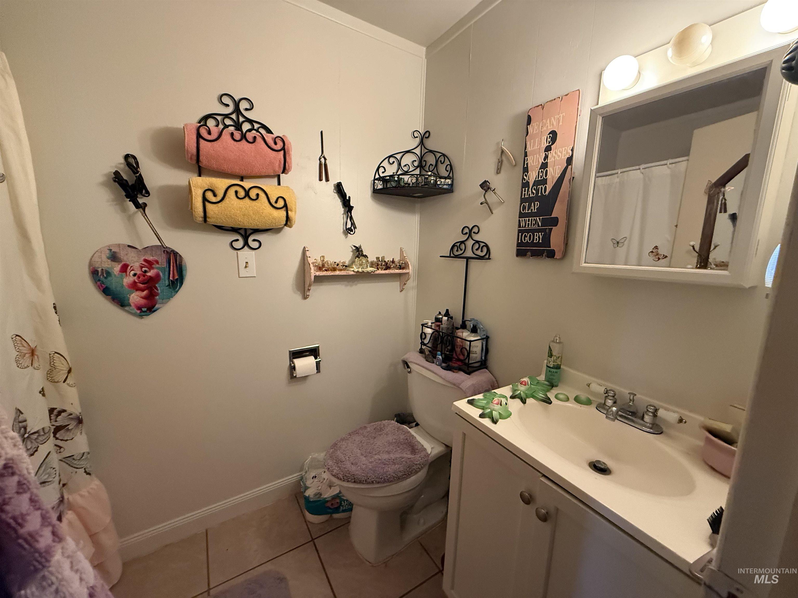 Full bathroom with a shower with shower curtain, vanity, and light tile patterned floors