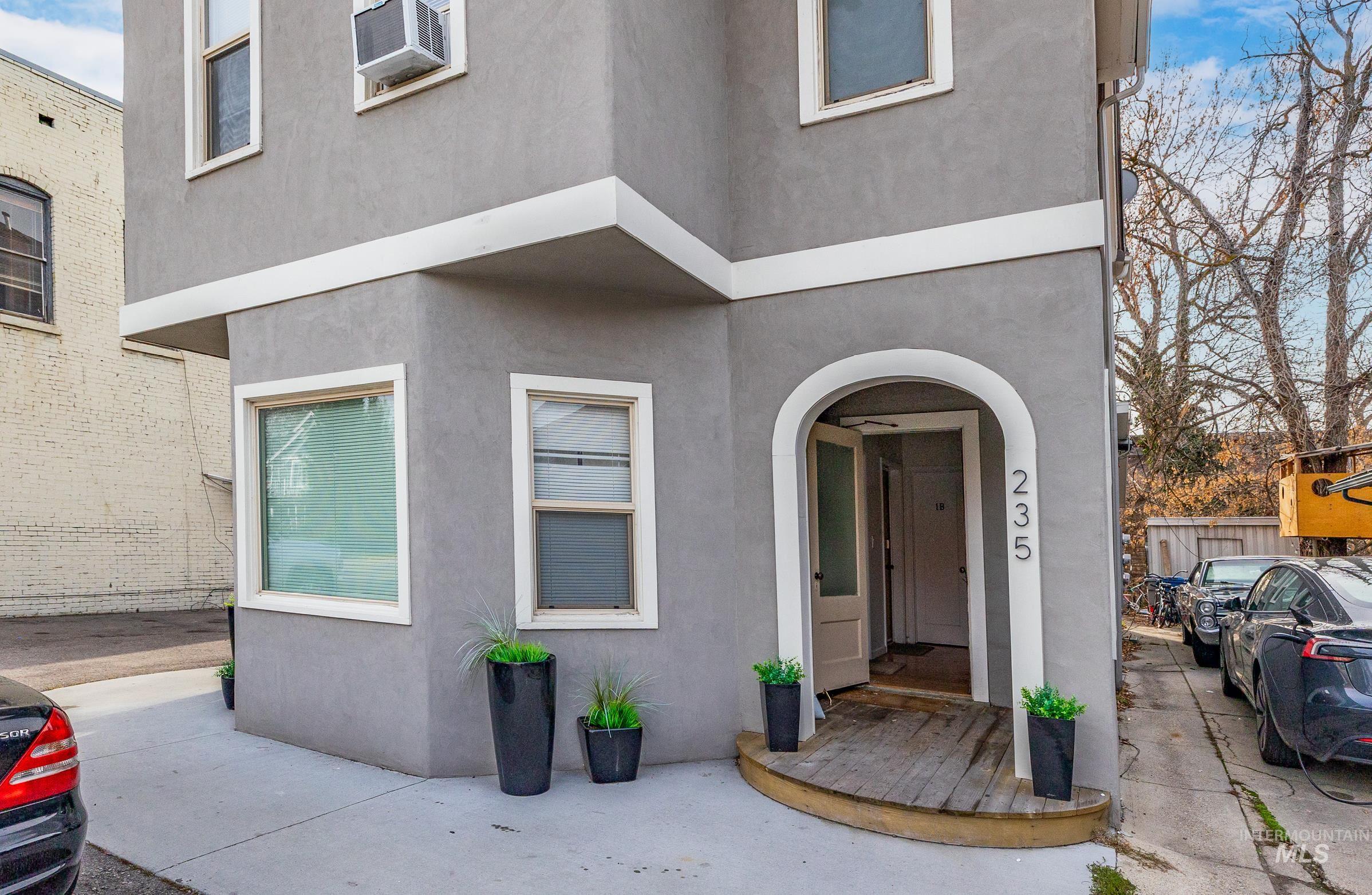 Doorway to property with stucco siding and cooling unit
