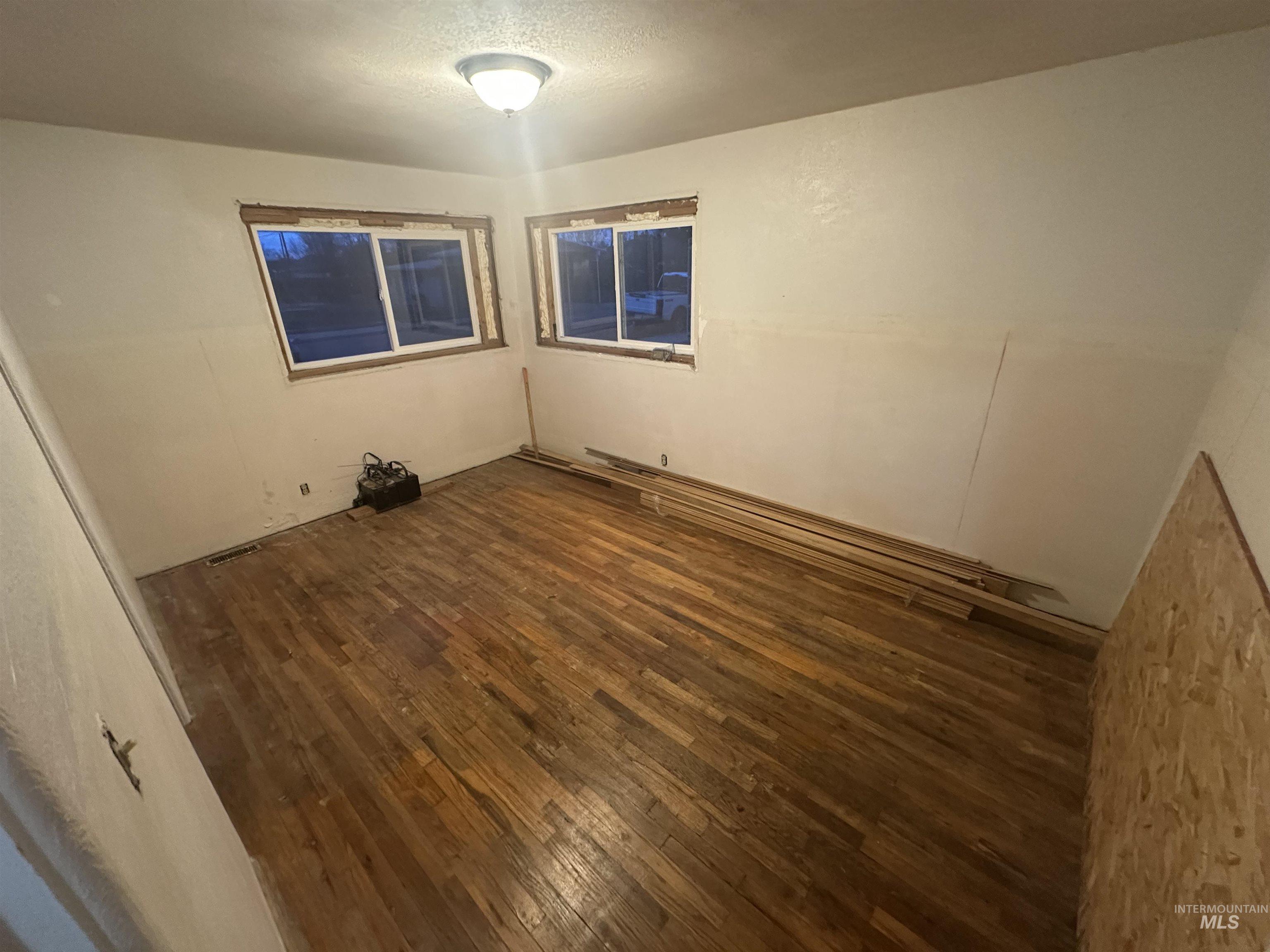 Spare room with dark wood-type flooring and a textured ceiling