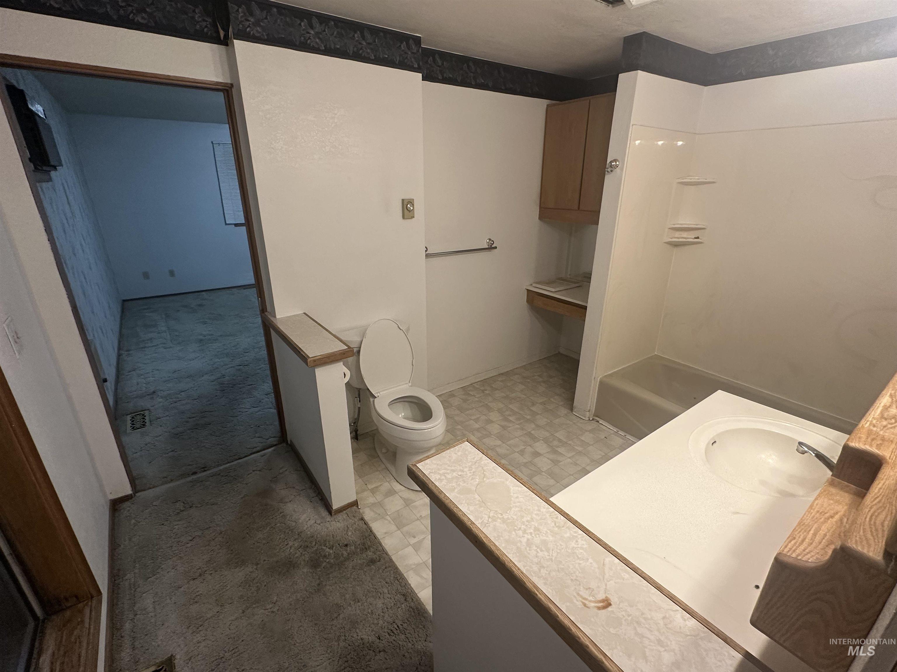 Full bath with light floors, vanity, a shower, and light colored carpet