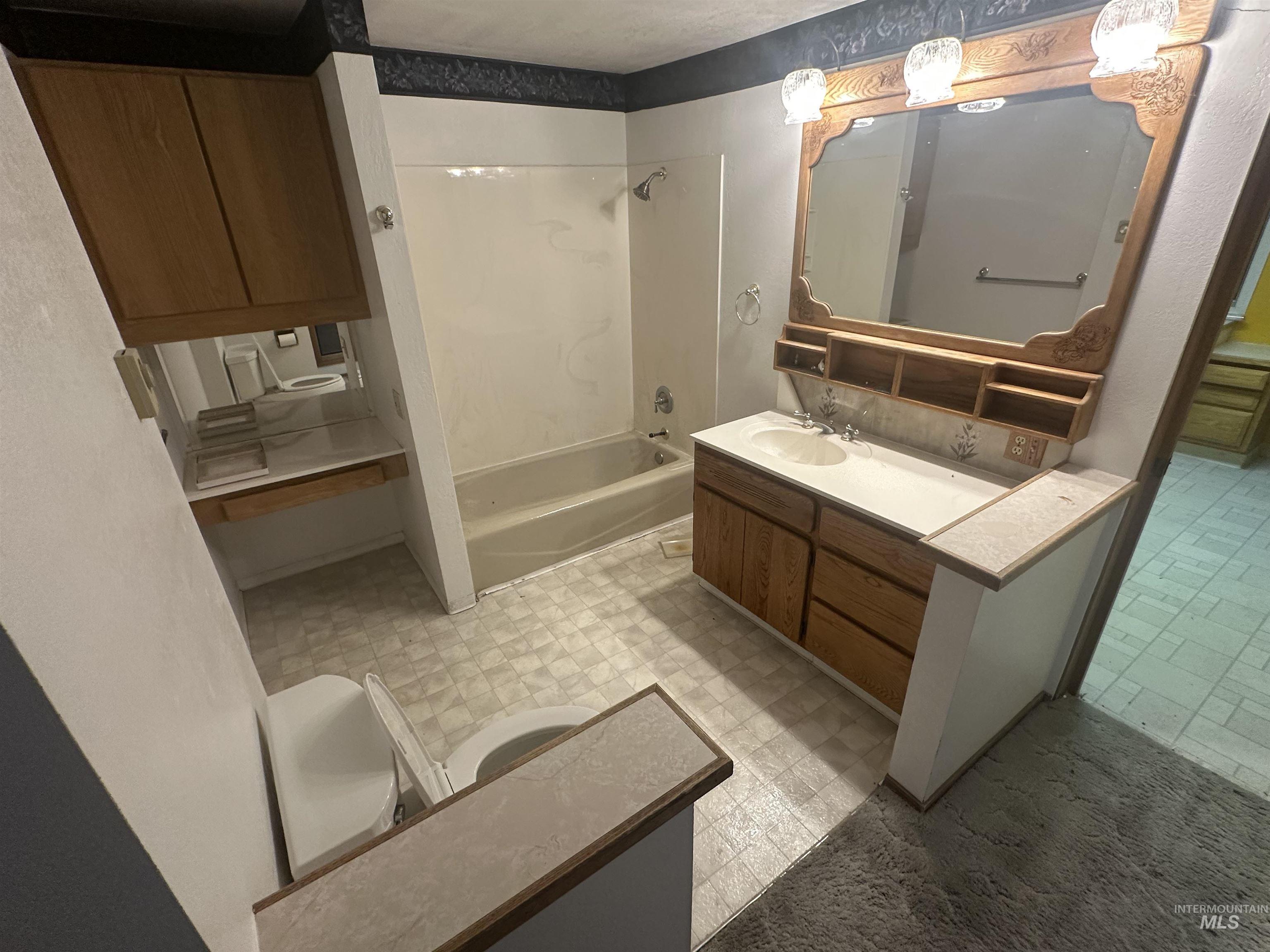 Full bathroom featuring light flooring, vanity, and bathing tub / shower combination