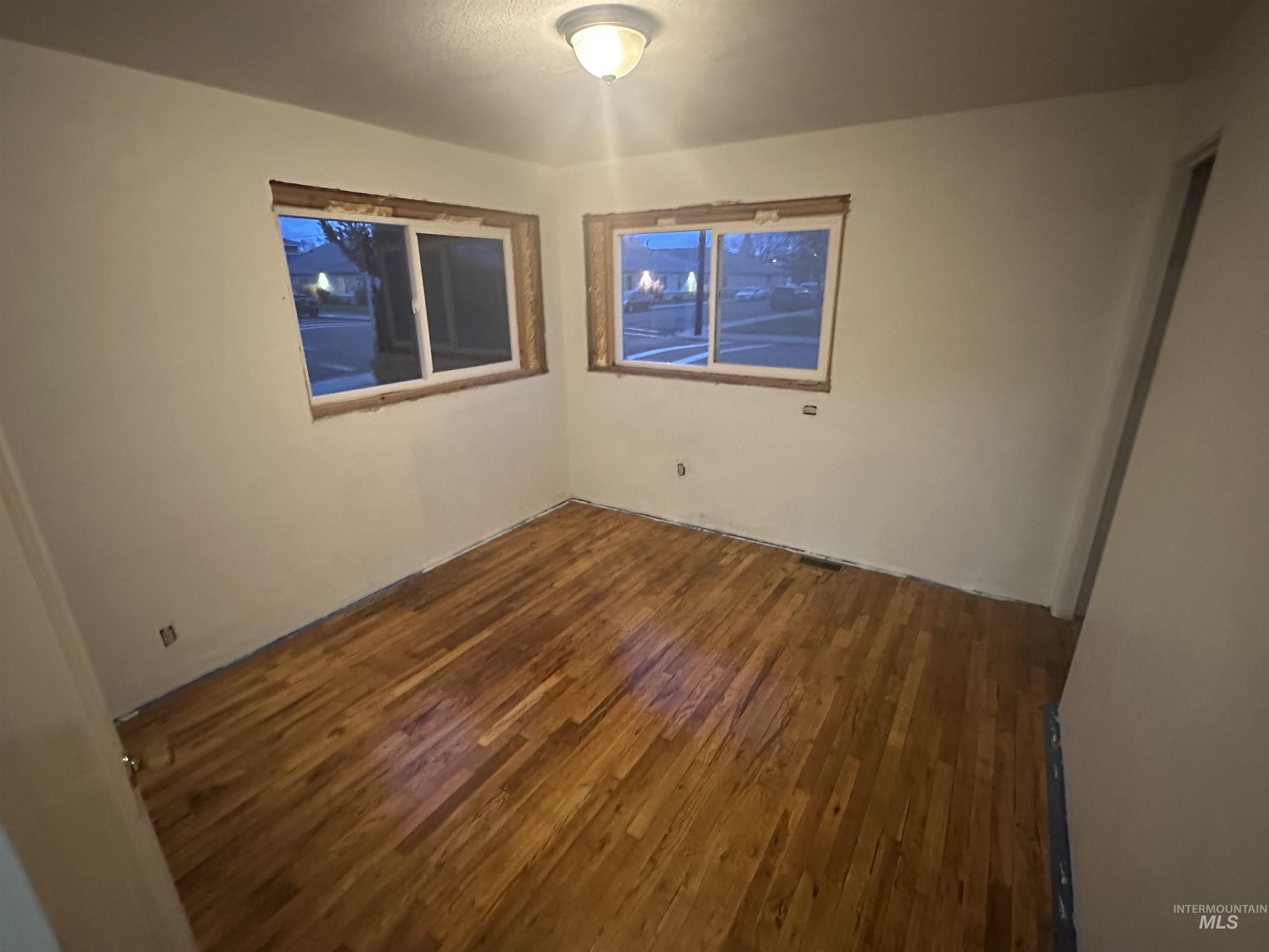 Spare room with dark wood-style floors