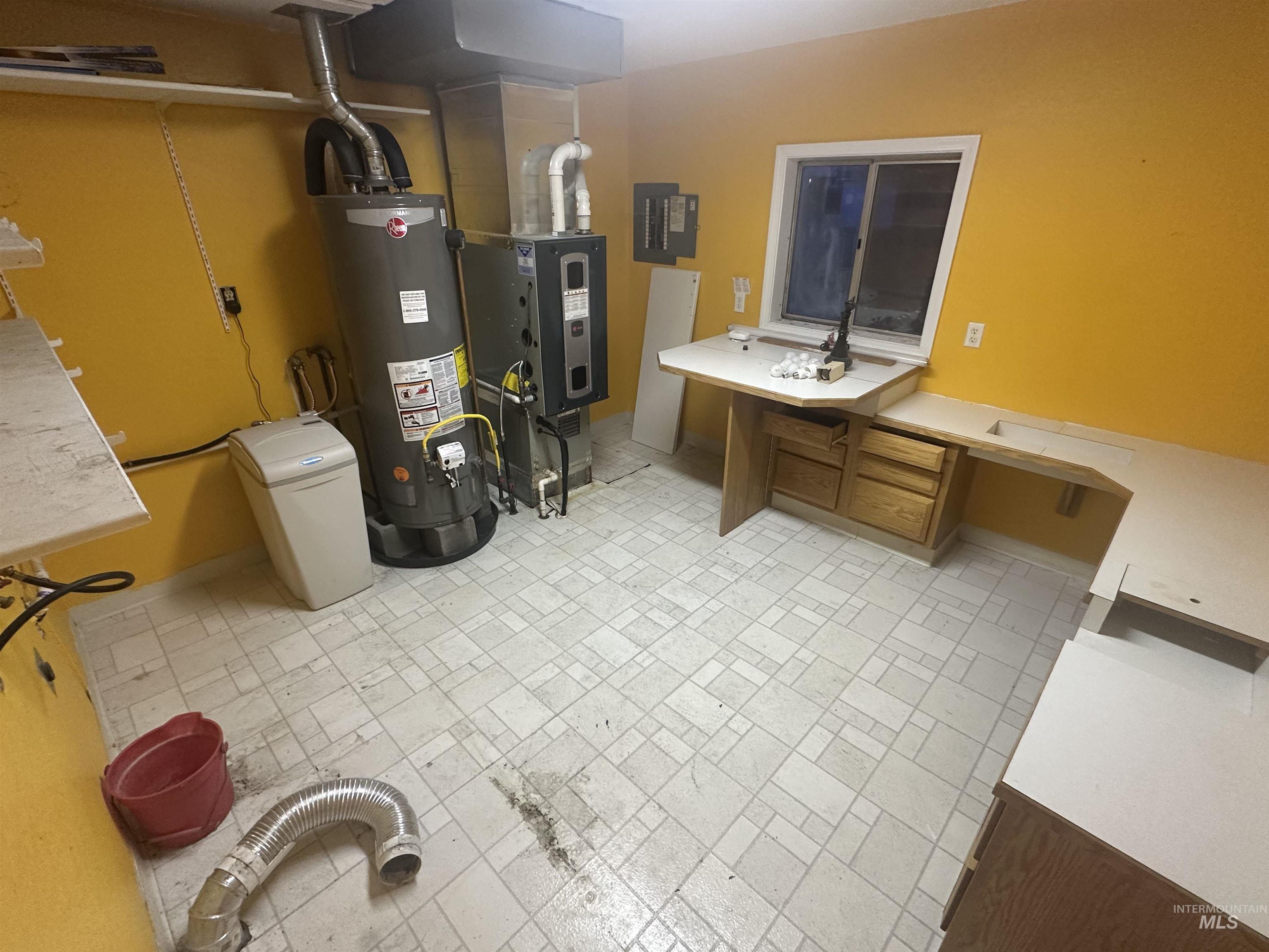 Utilities featuring water heater, electric panel, and heating unit