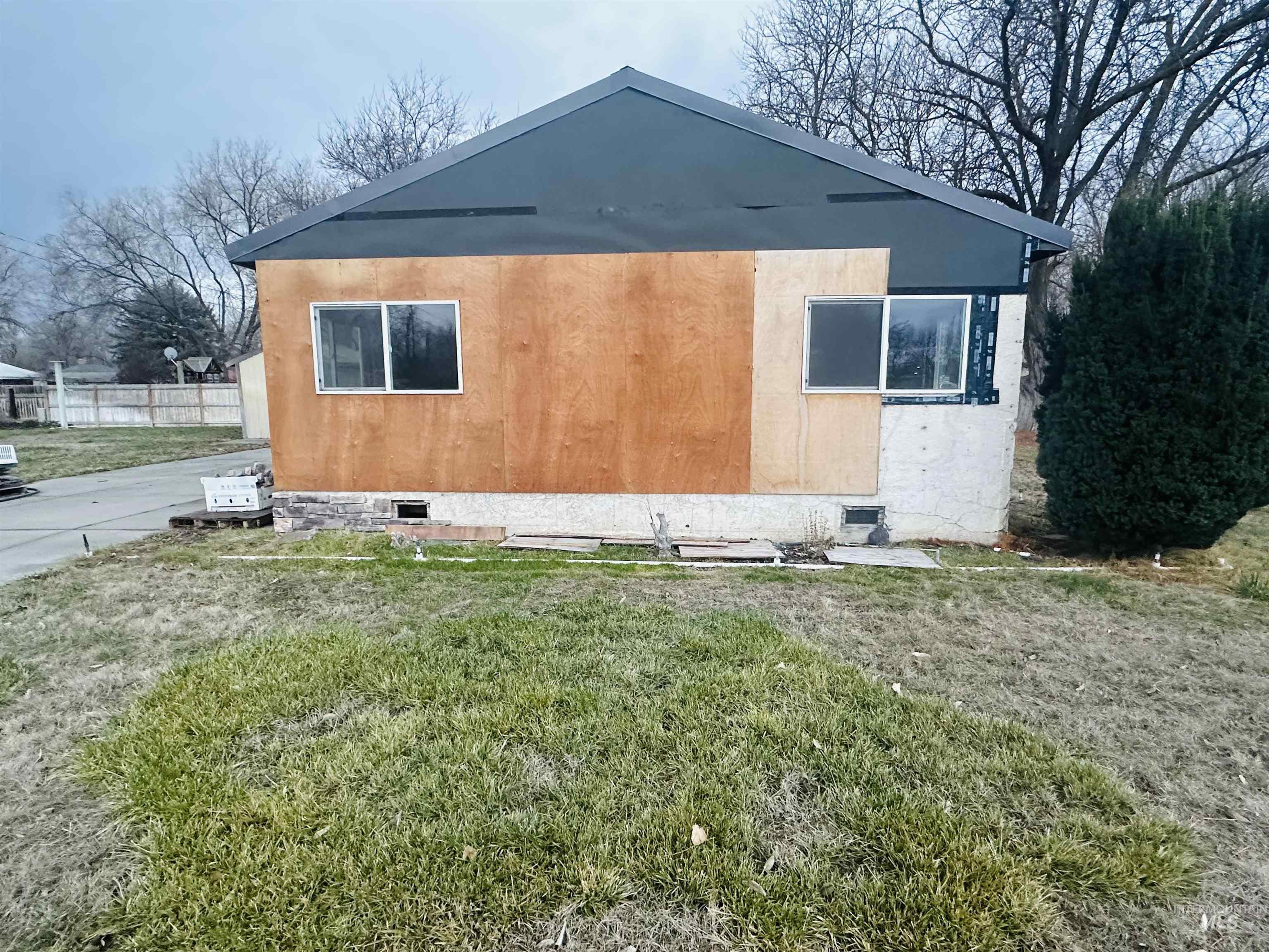 View of side of property with a yard, stucco siding, and crawl space