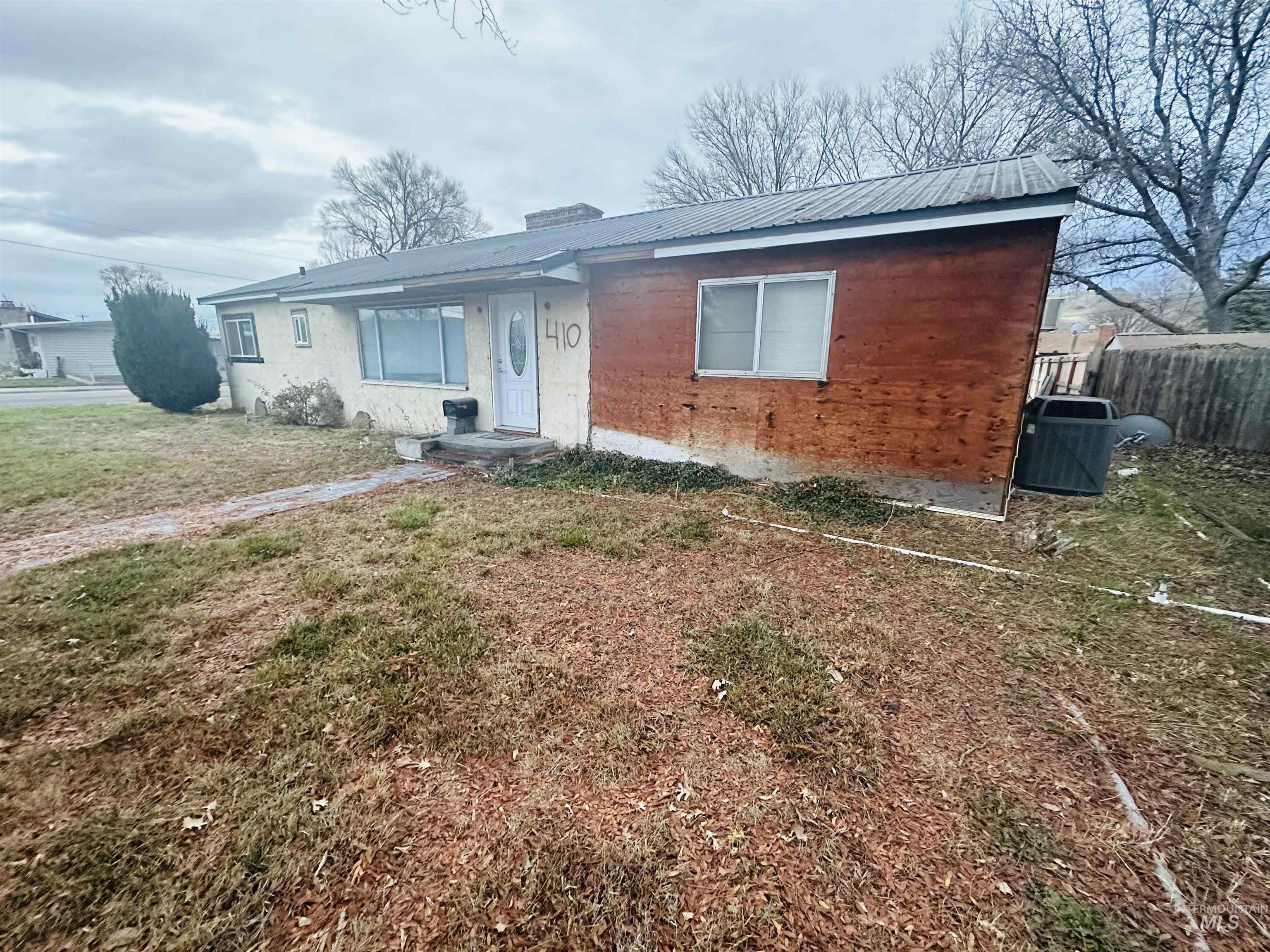 View of front of property featuring a chimney and a metal roof