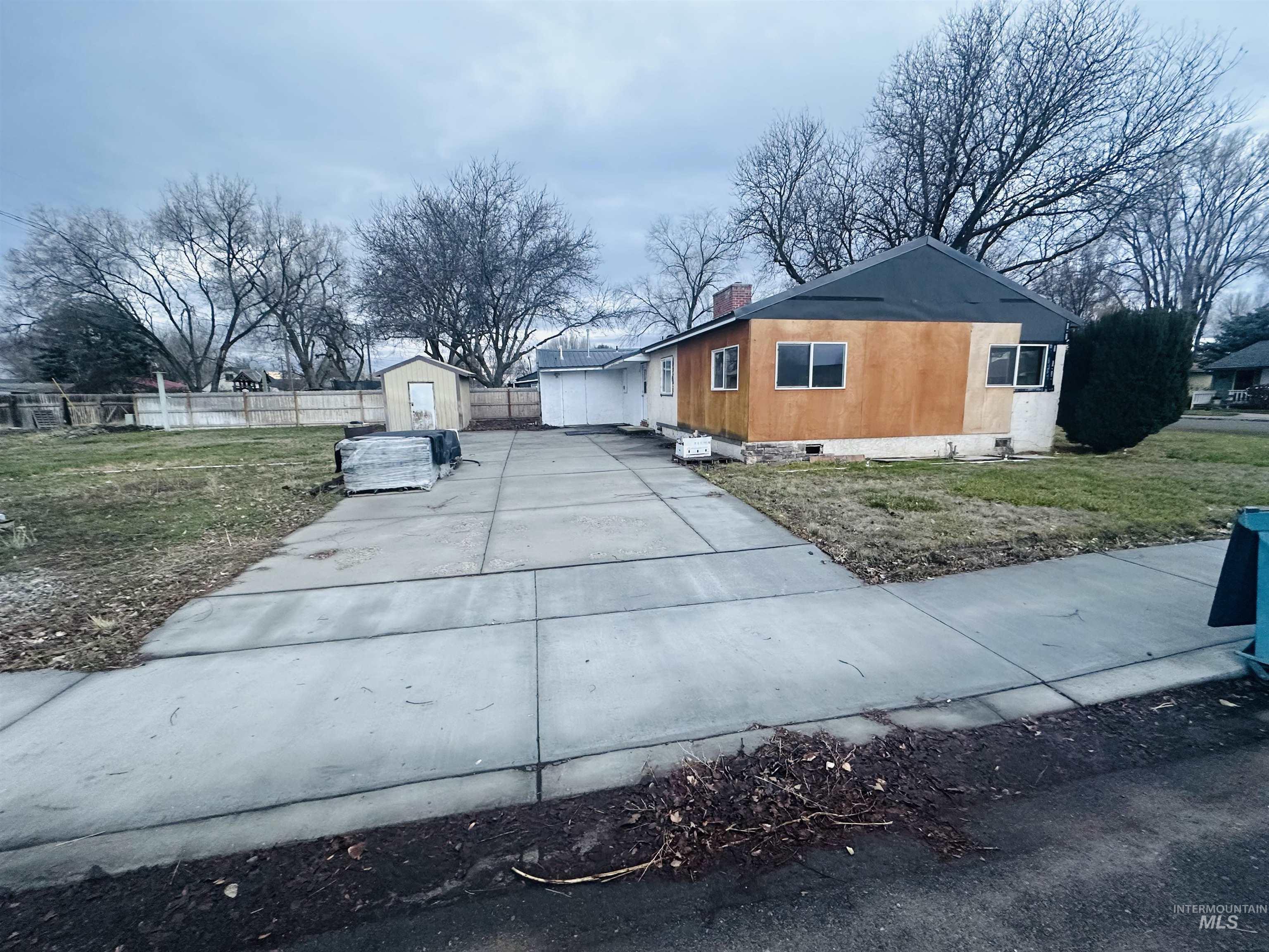 View of property exterior featuring a chimney, driveway, crawl space, and an outdoor structure