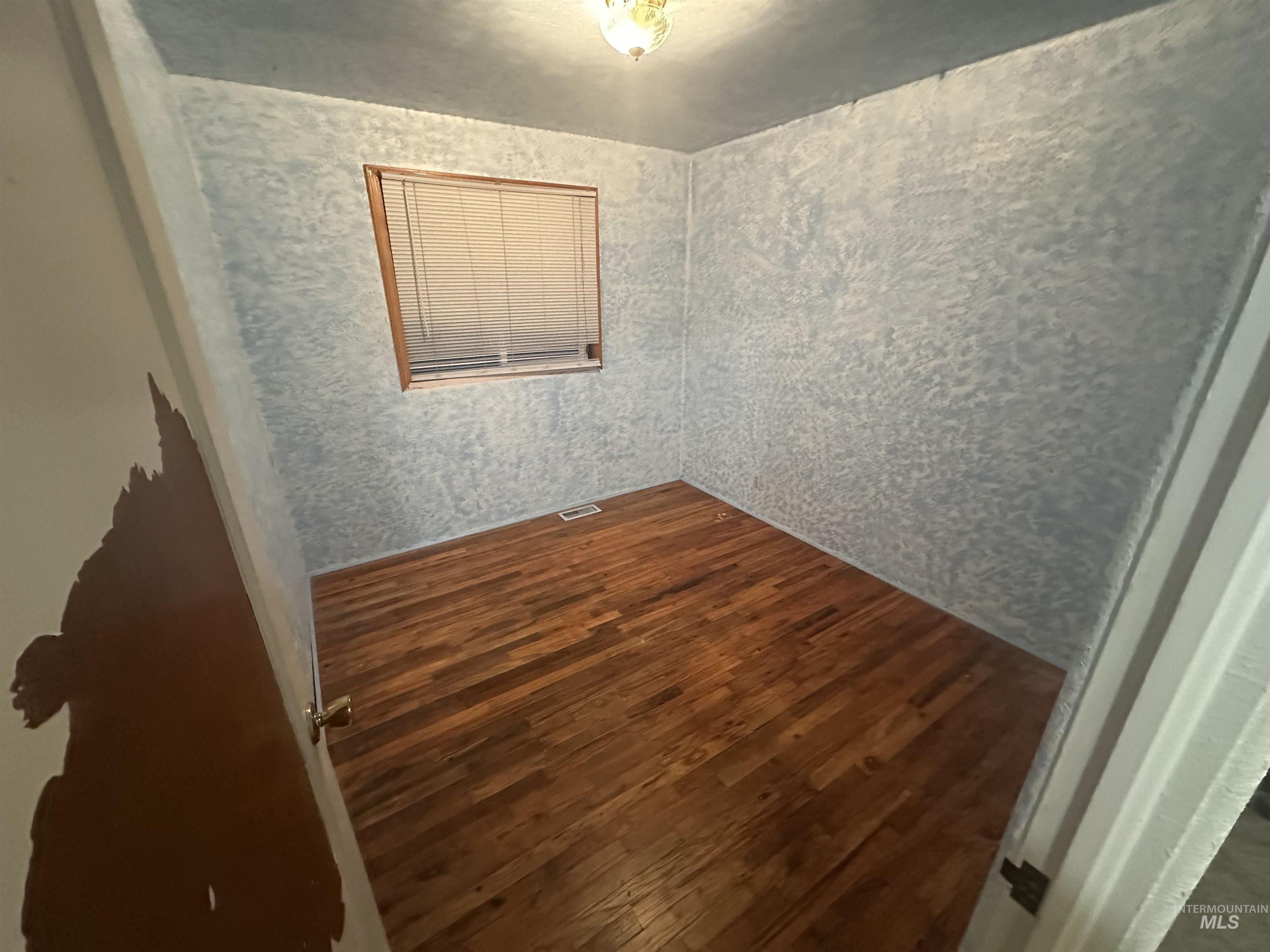 Unfurnished room with dark wood-type flooring